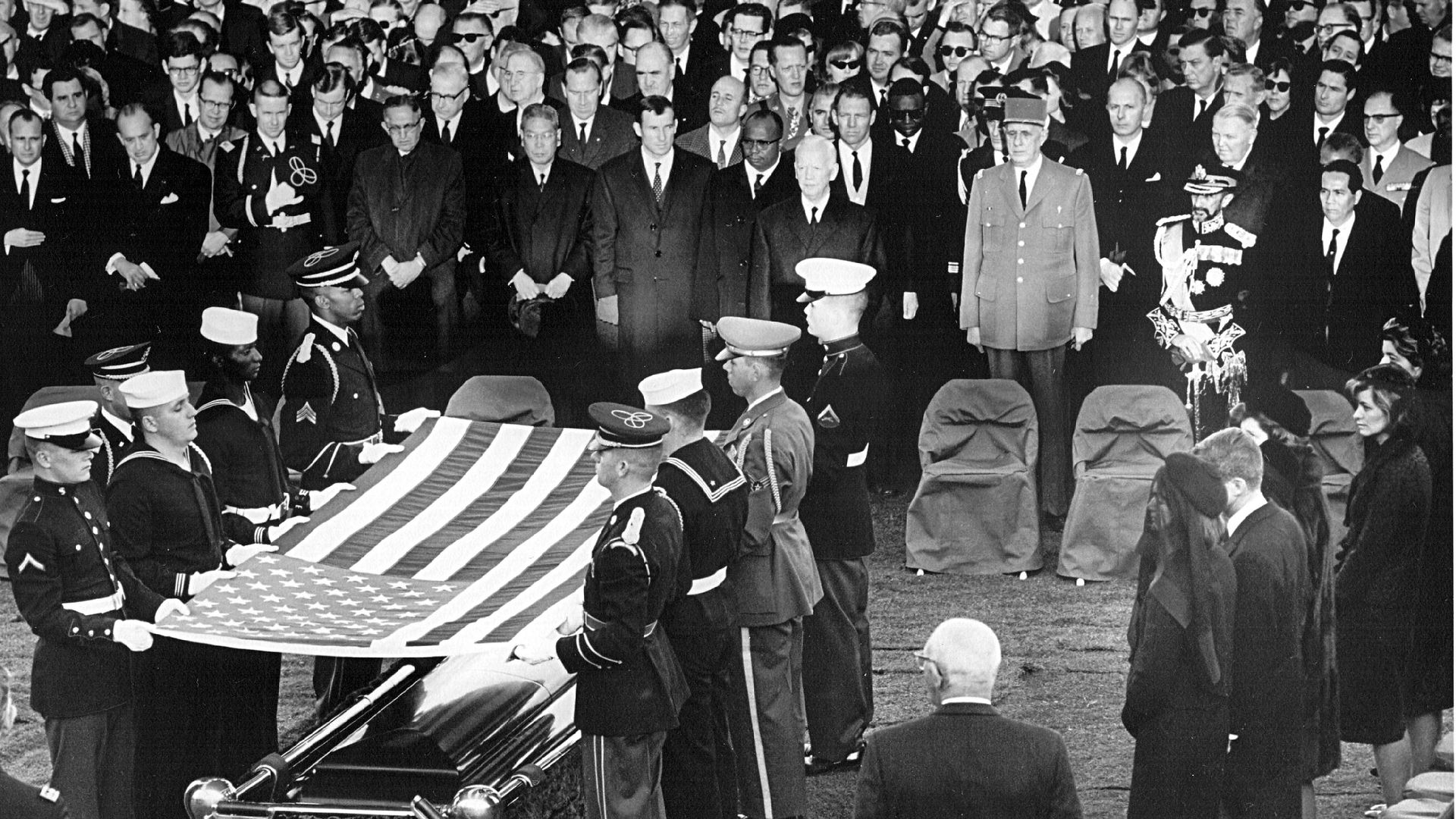 Honor guard place a flag over the casket of President John F. Kennedy during his funeral service November 25, 1963 in Arlington Cemetery
