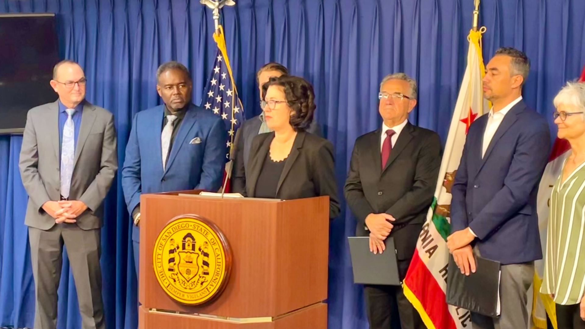 Lisa Jones, new CEO of the San Diego Housing Commission, stands at a podium with other city leaders.
