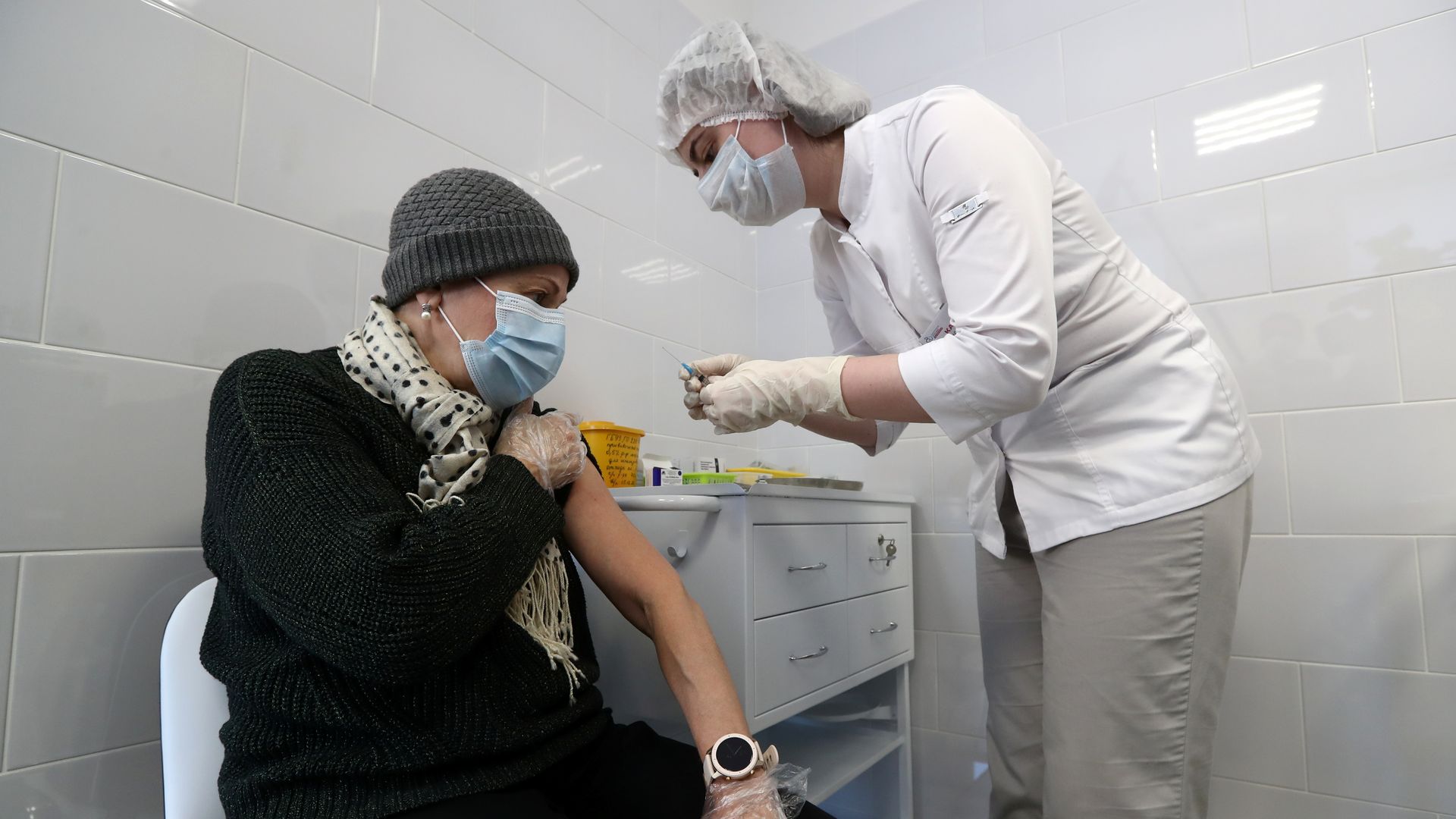 Picture of a medical worker injecting a man with a vaccine against COVID-19