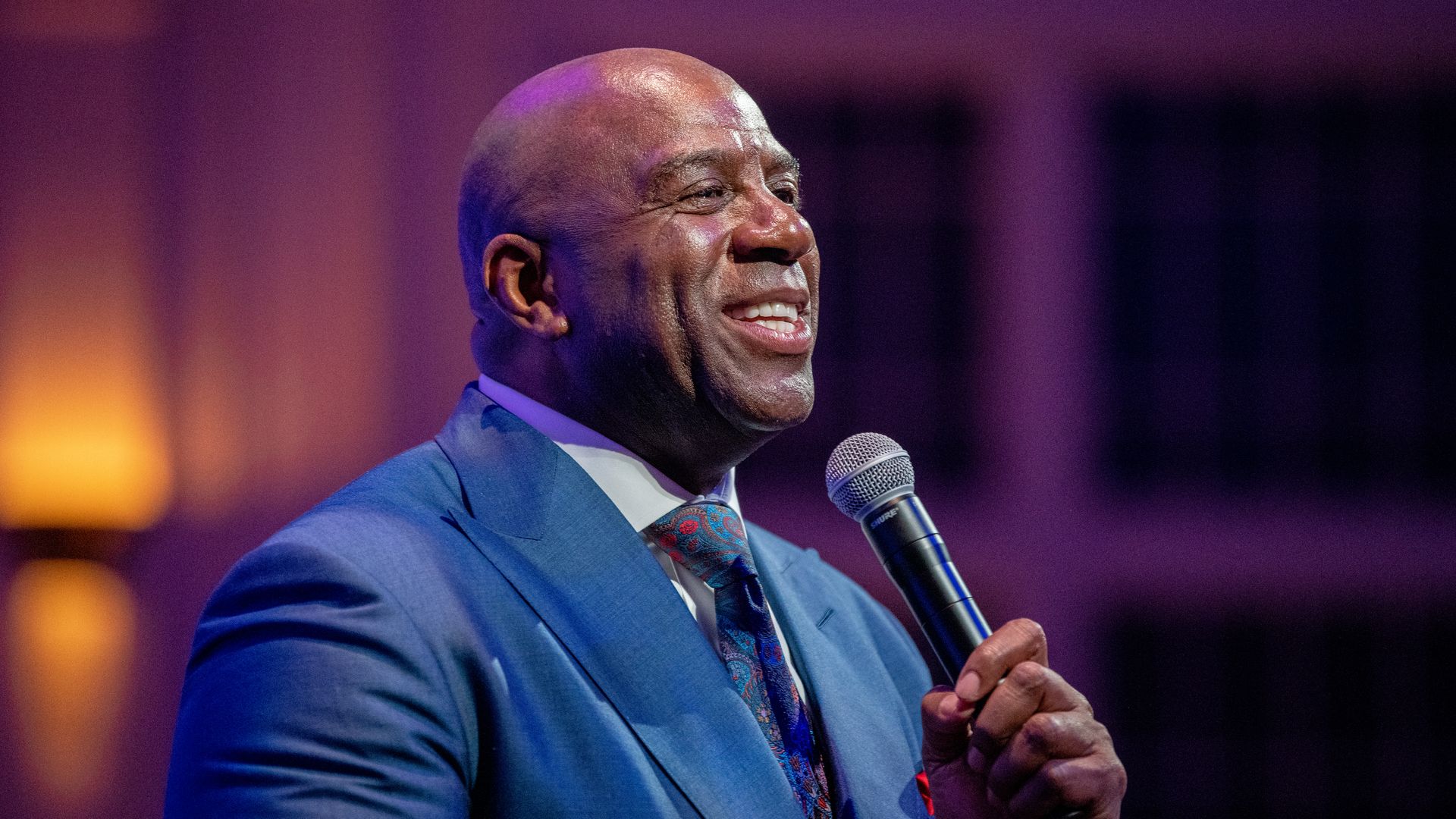 Magic Johnson holding a microphone and giving a speech