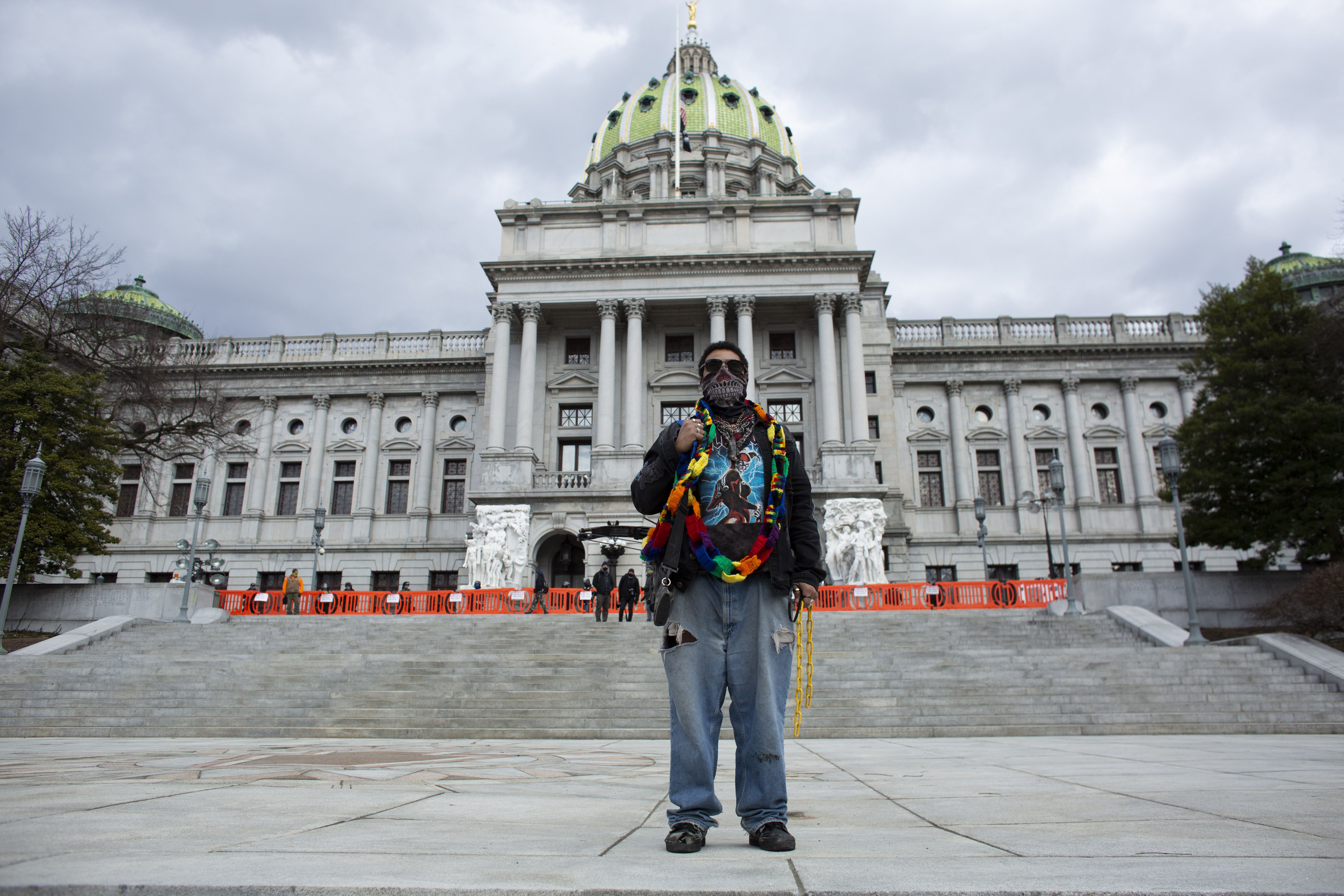 A protester carries a crossbow outside the Capitol in Harrisburg, Pennsylvania on January 17
