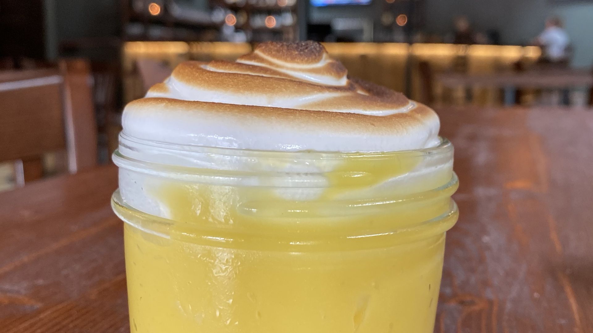 bright yellow custard dessert in a mason jar