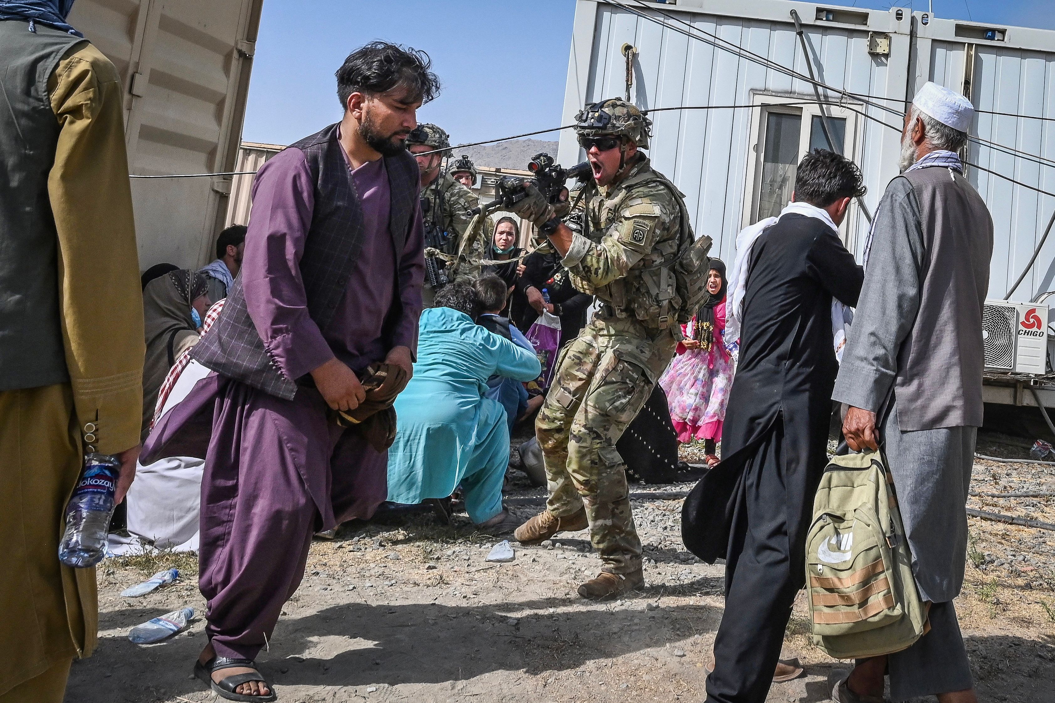 US soldier pointing gun at Afghan