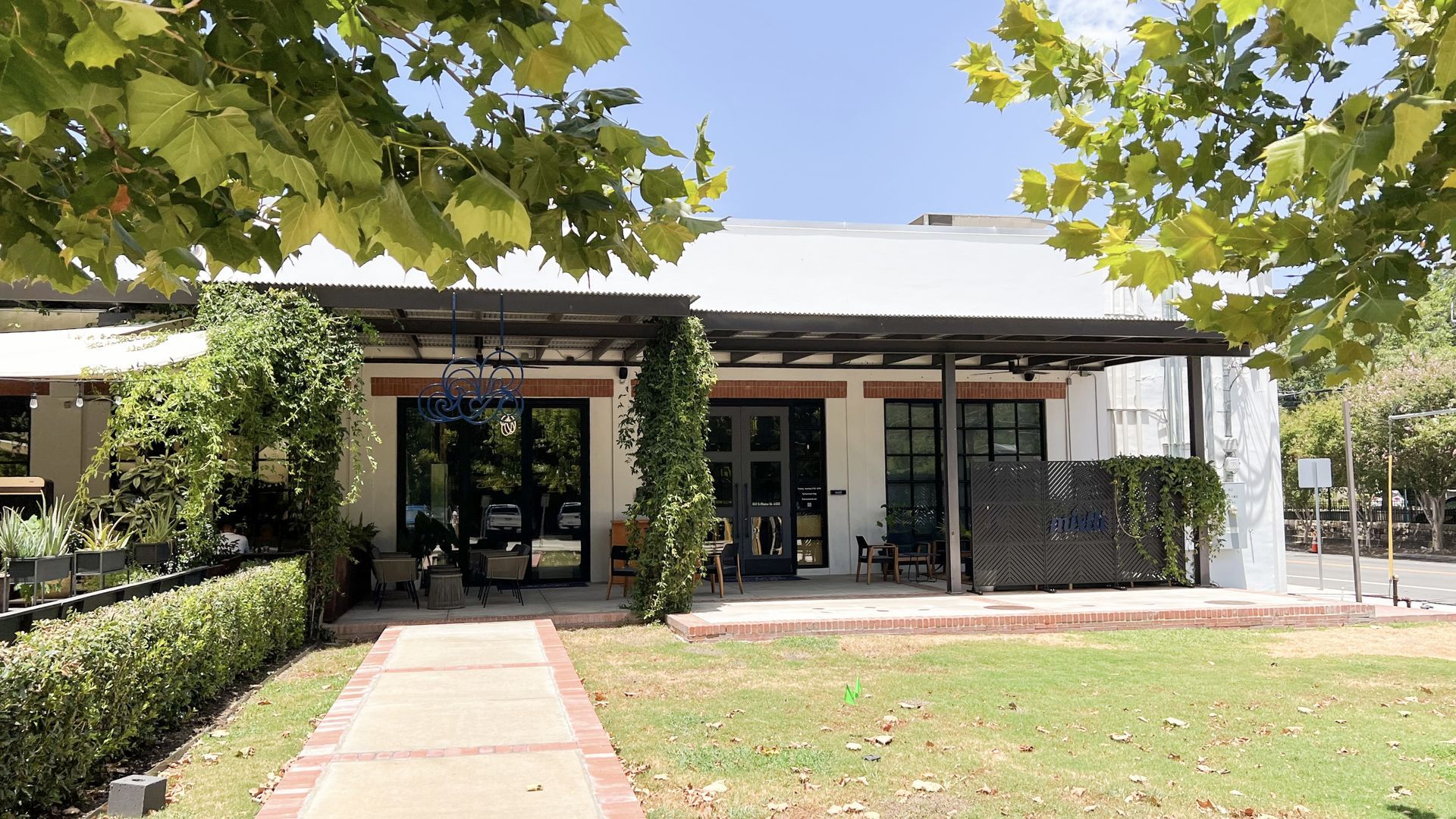 A white building surrounded by leafy trees.