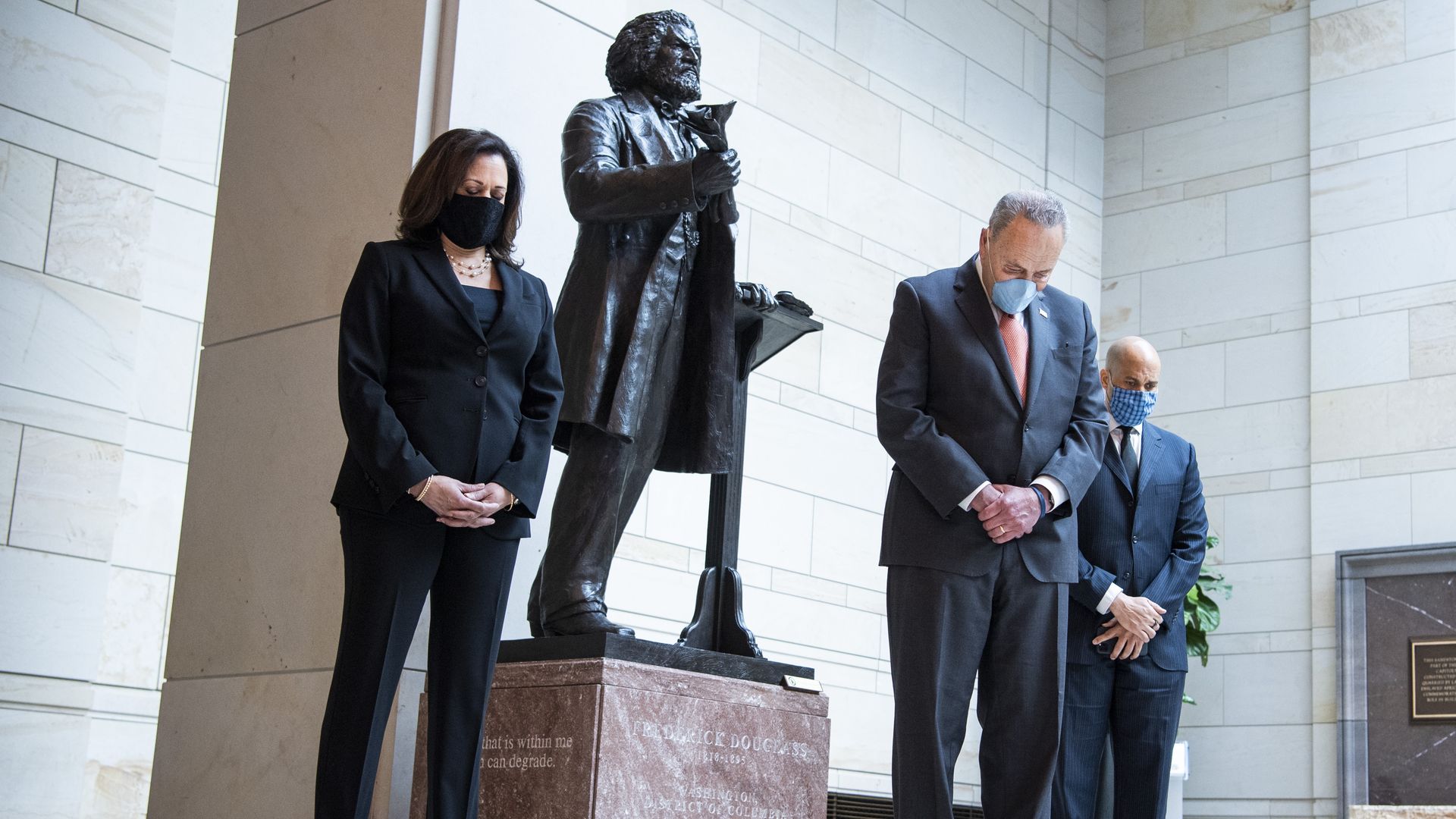 From left, Sen. Kamala Harris, D-Calif., Senate Minority Leader Charles Schumer, D-N.Y., and Sen. Cory Booker, D-N.J. bow their heads