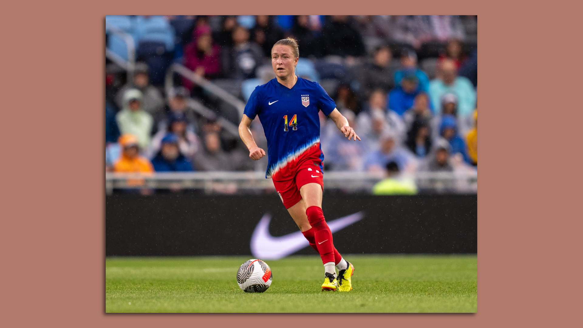 An individual playing for the U.S women's national team kicks a soccer ball