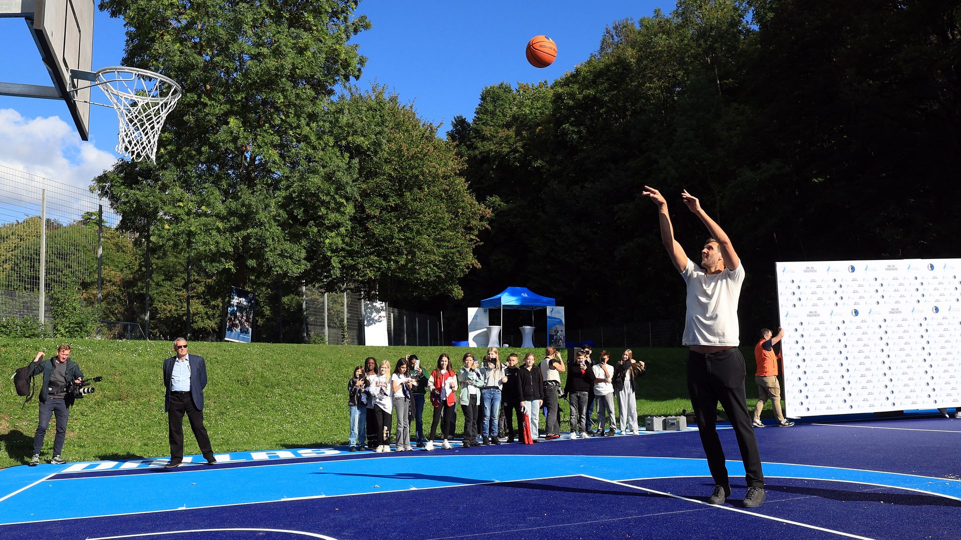 Dirk Nowitzki shoots a basket on a blue court