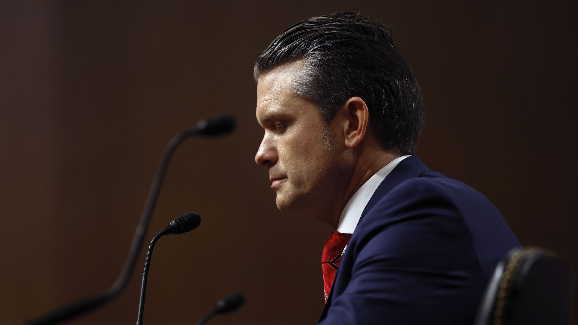 Side view of Pete Hegseth at a microphone