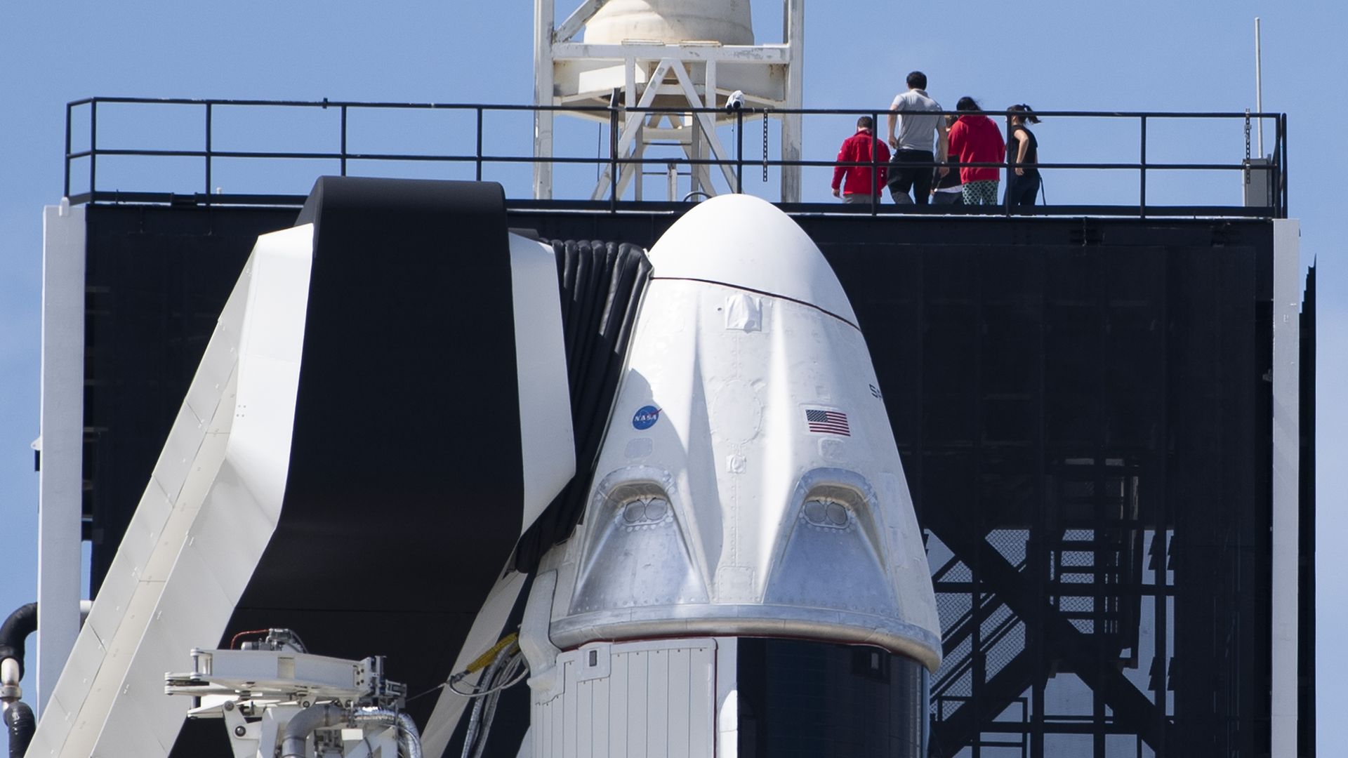 The SpaceX Falcon 9 rocket with the unmanned Crew Dragon capsule on its nose sits at Kennedy Space Center in Florida.