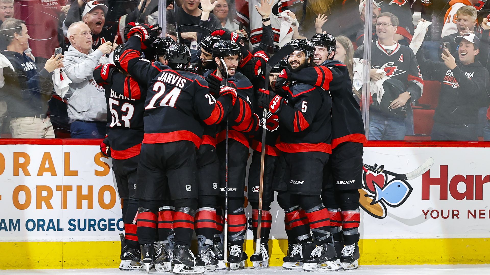 The Carolina Hurricanes celebrate in a large group of teammates after scoring the game-winning goal to defeat the Philadelphia Flyers at home on May 4.