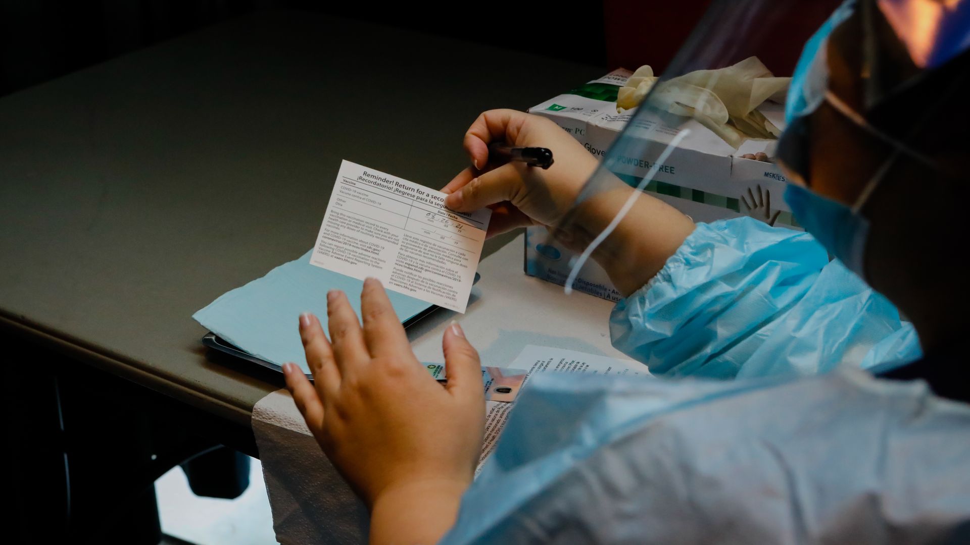 A healthcare worker holds a Covid-19 vaccination card during an event hosted by the Miami Heat at the FTX Arena in Miami, Florida, U.S., on Thursday, Aug. 5, 2021.