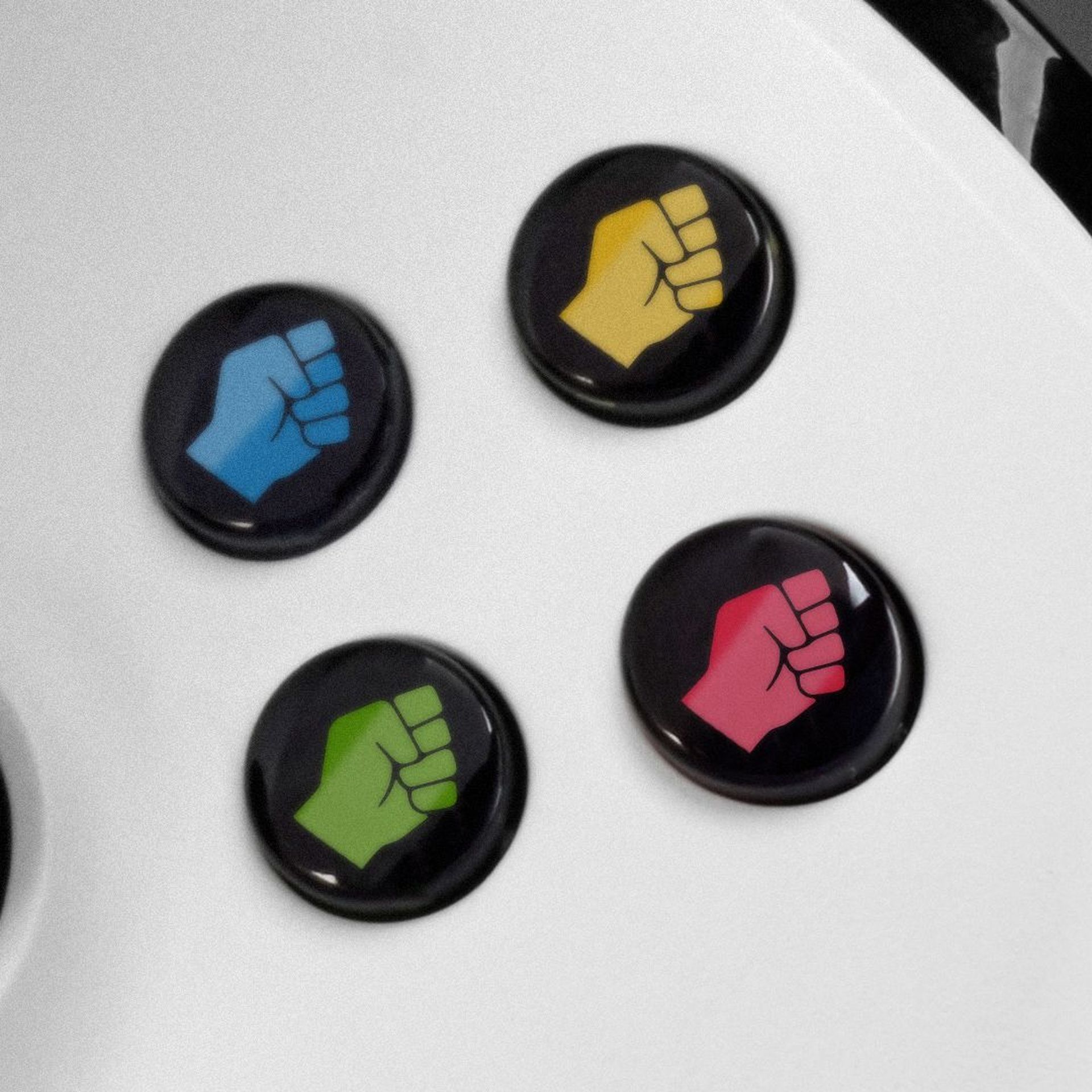 Illustration of a gaming controller with different fist icons on the buttons. 