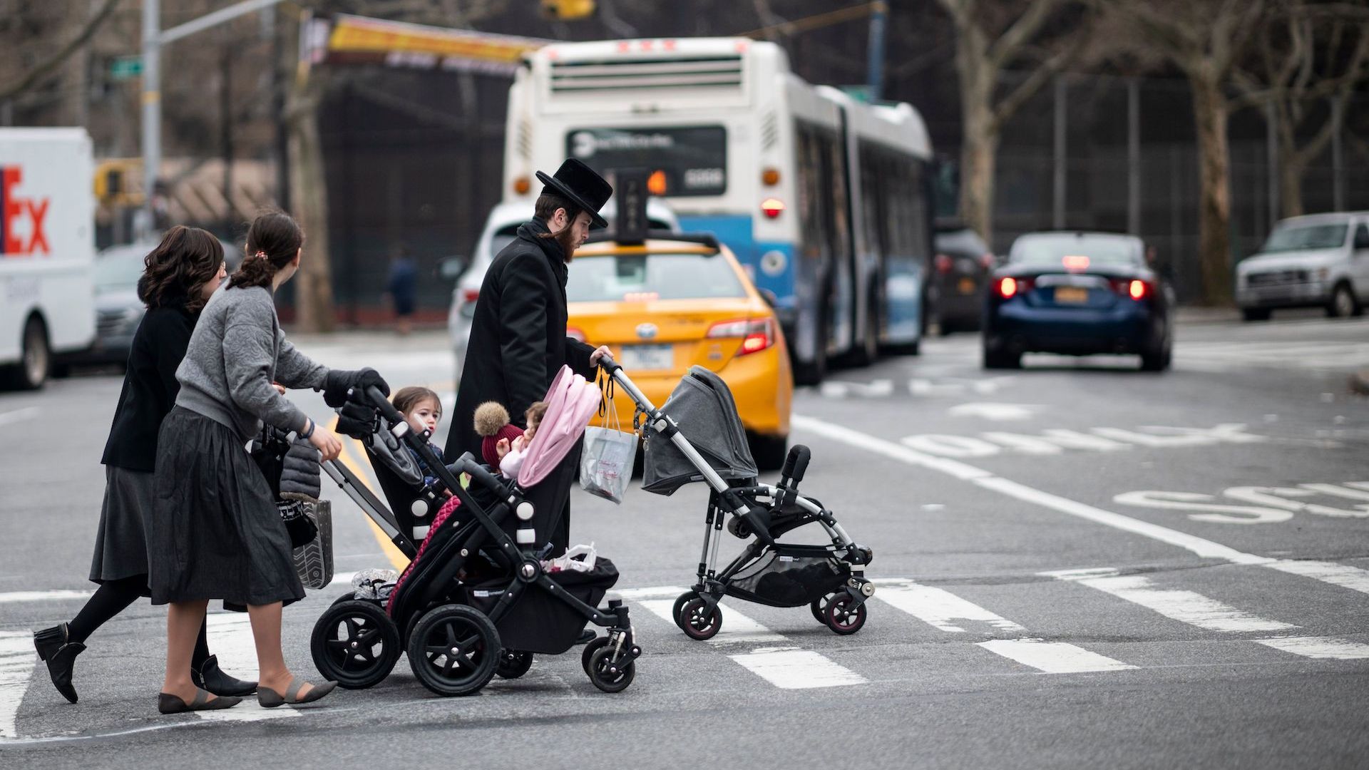 Orthodox Jewish parents push children in strollers in Williamsburg, Brooklyn, where a measles outbreak is underway