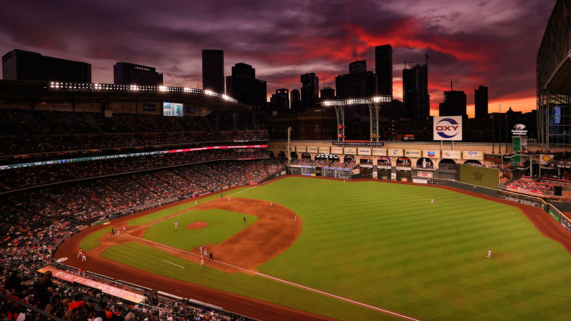 A wide view of the inside of Minute Maid Park with the roof open.