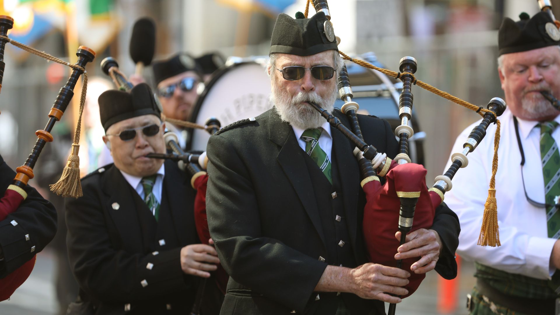 Photo of people dressed in uniform playing the bagpipes in a parade