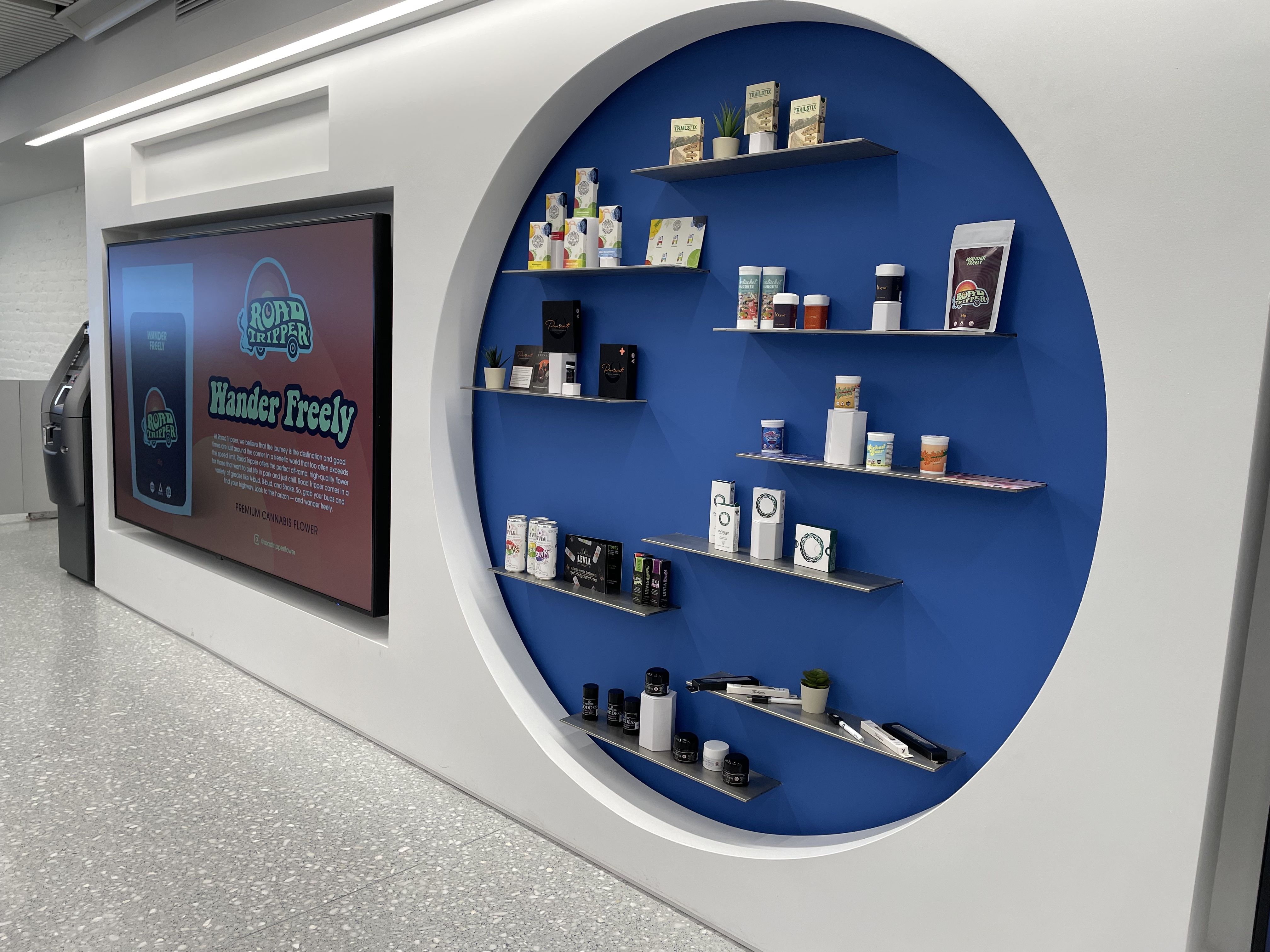 Ayr Wellness displays its own products on its "wonder wall," a blue circular area on the right wall. 