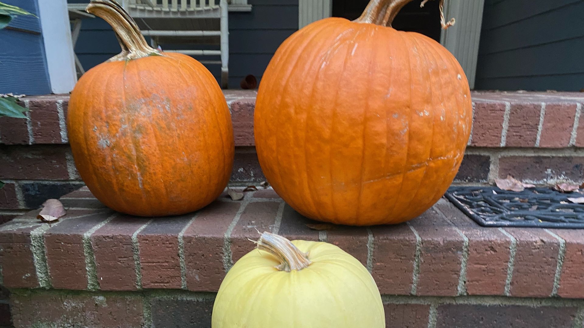 three pumpkins on a stoop