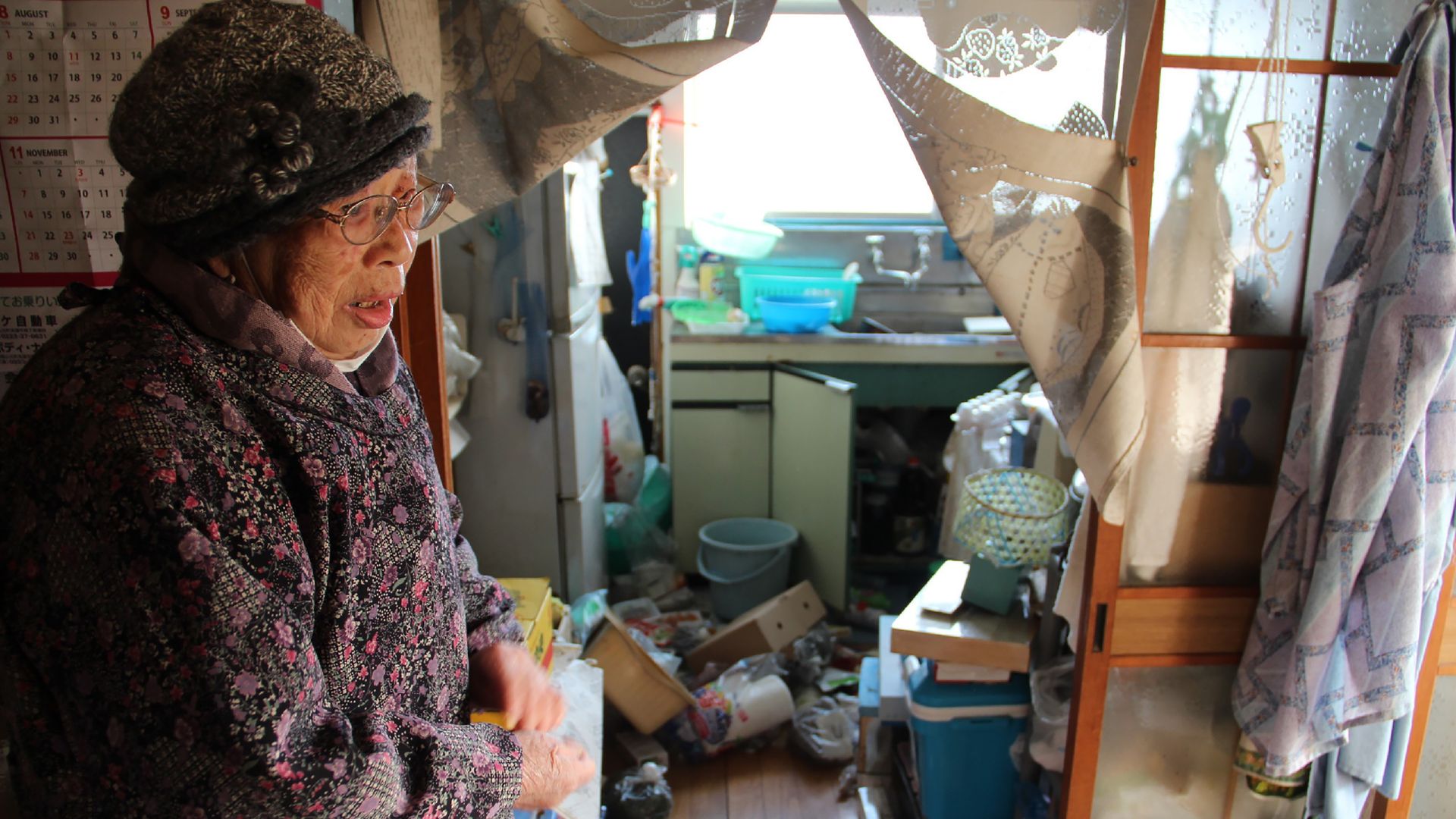 Japanese woman Taeko Naito stands next to her scattered kitchen at her home in Soma, Fukushima prefecture on February 14, 2021, after a 7.3-magnitude earthquake struck off Japan's east coast