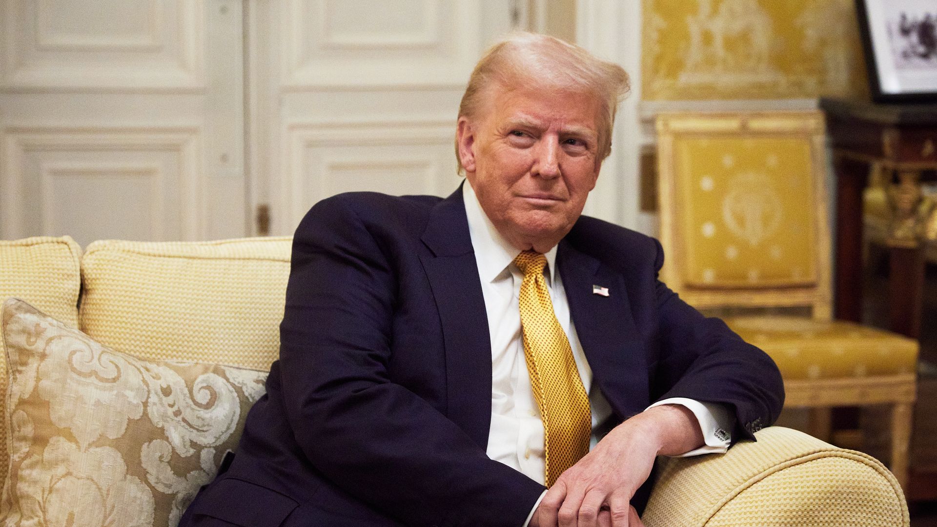 President-elect Trump leans on the armrest of a couch during an official visit in Paris in December 2024.