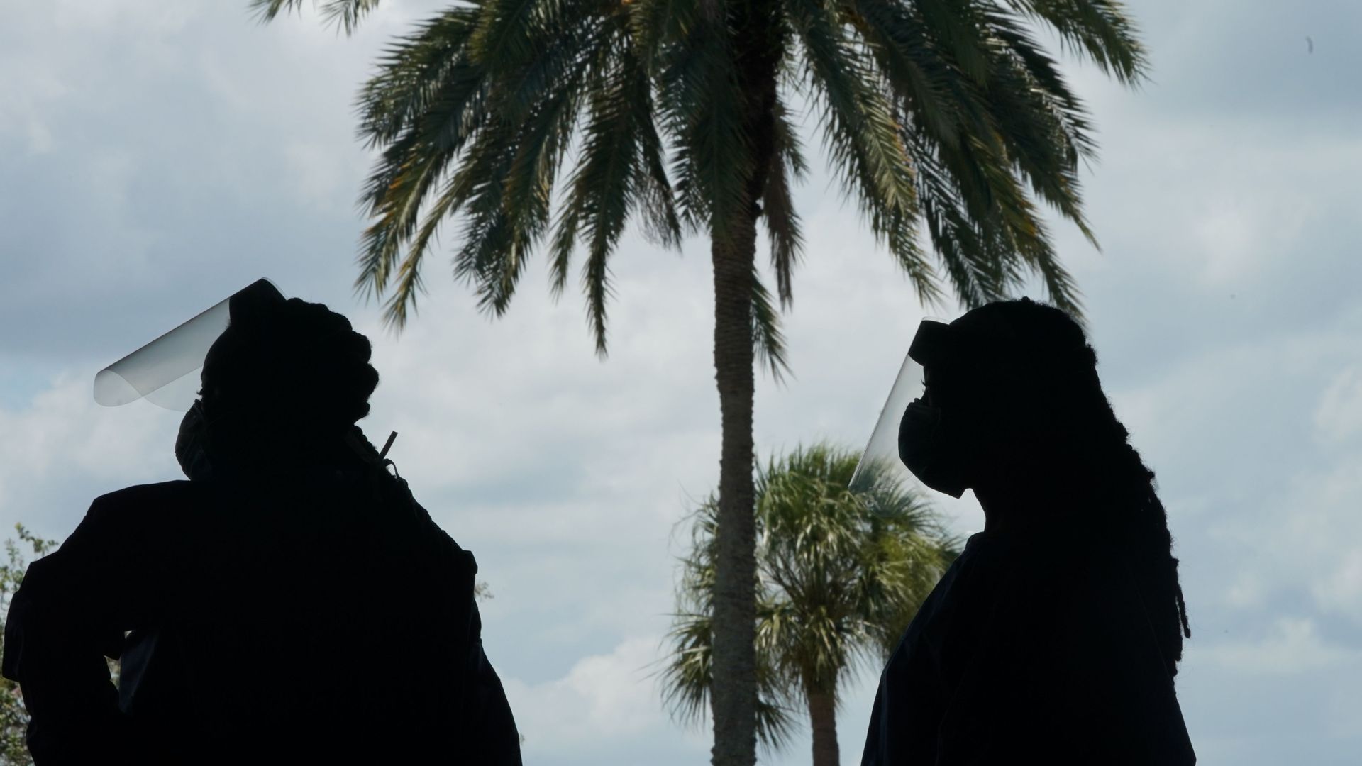  Medical workers wait for a vehicle at a drive-thru COVID-19 testing site at the Mahaffey Theater on July 24, 2020 in St. Petersburg, Florida