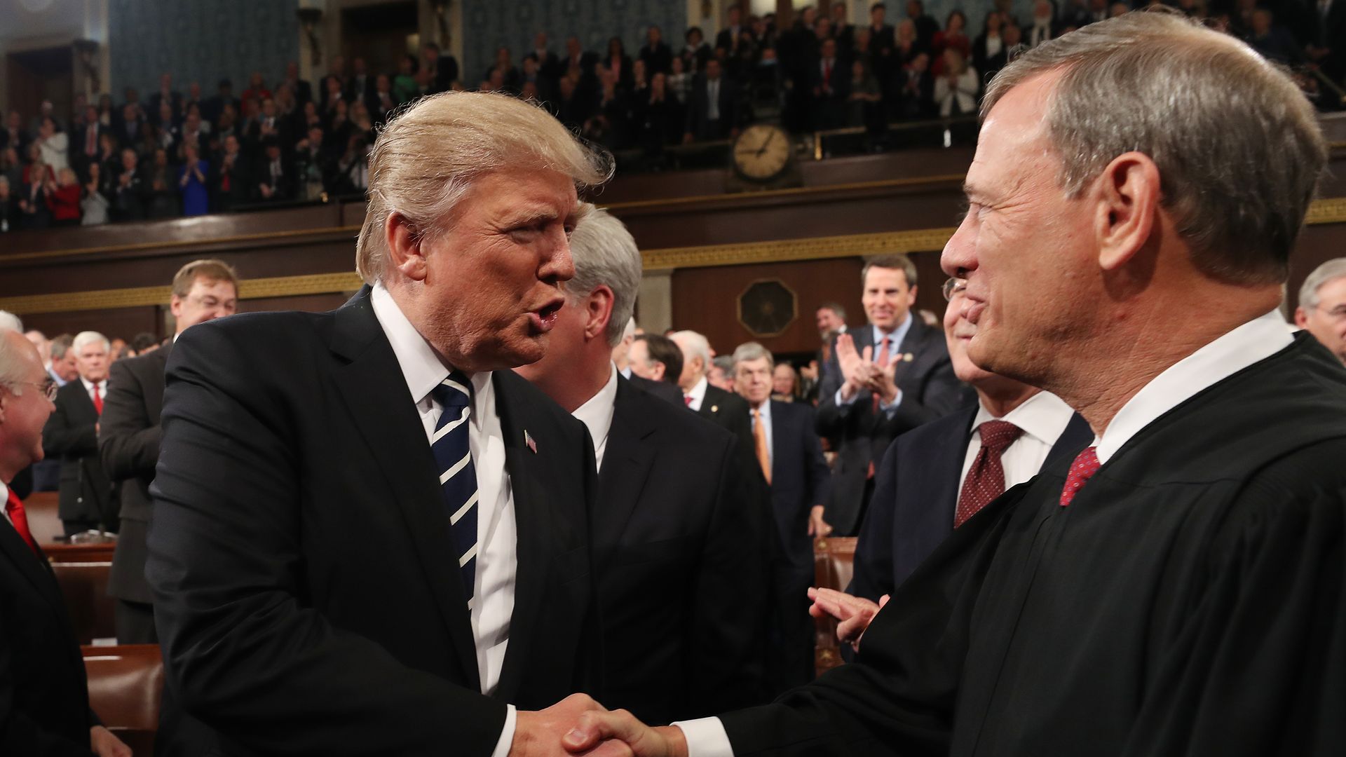 Donald Trump shakes hands with Supreme Court Chief Justice John Roberts. 