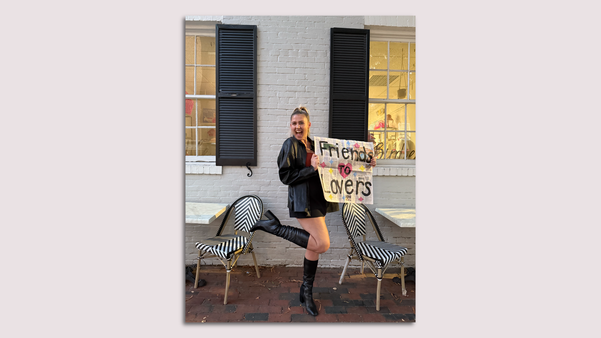 A photo showing a woman holding a newspaper with the words "Friends to Lovers" on it.