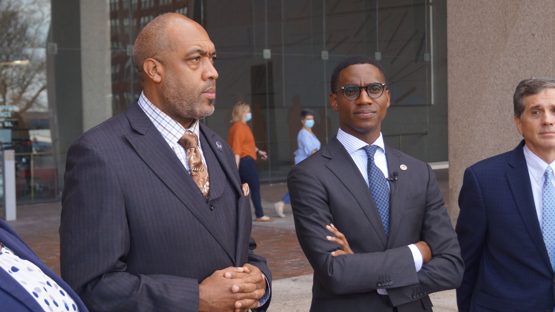 Blaine Griffin and Justin Bibb in suits outdoors. Bibb with arms crossed. 