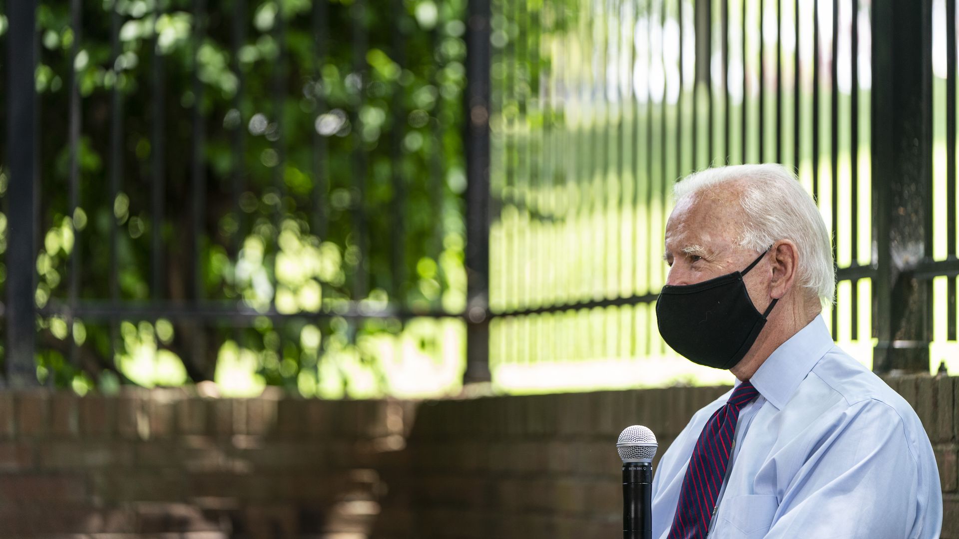 Biden wearing a face mask talking to a group of people about health care.
