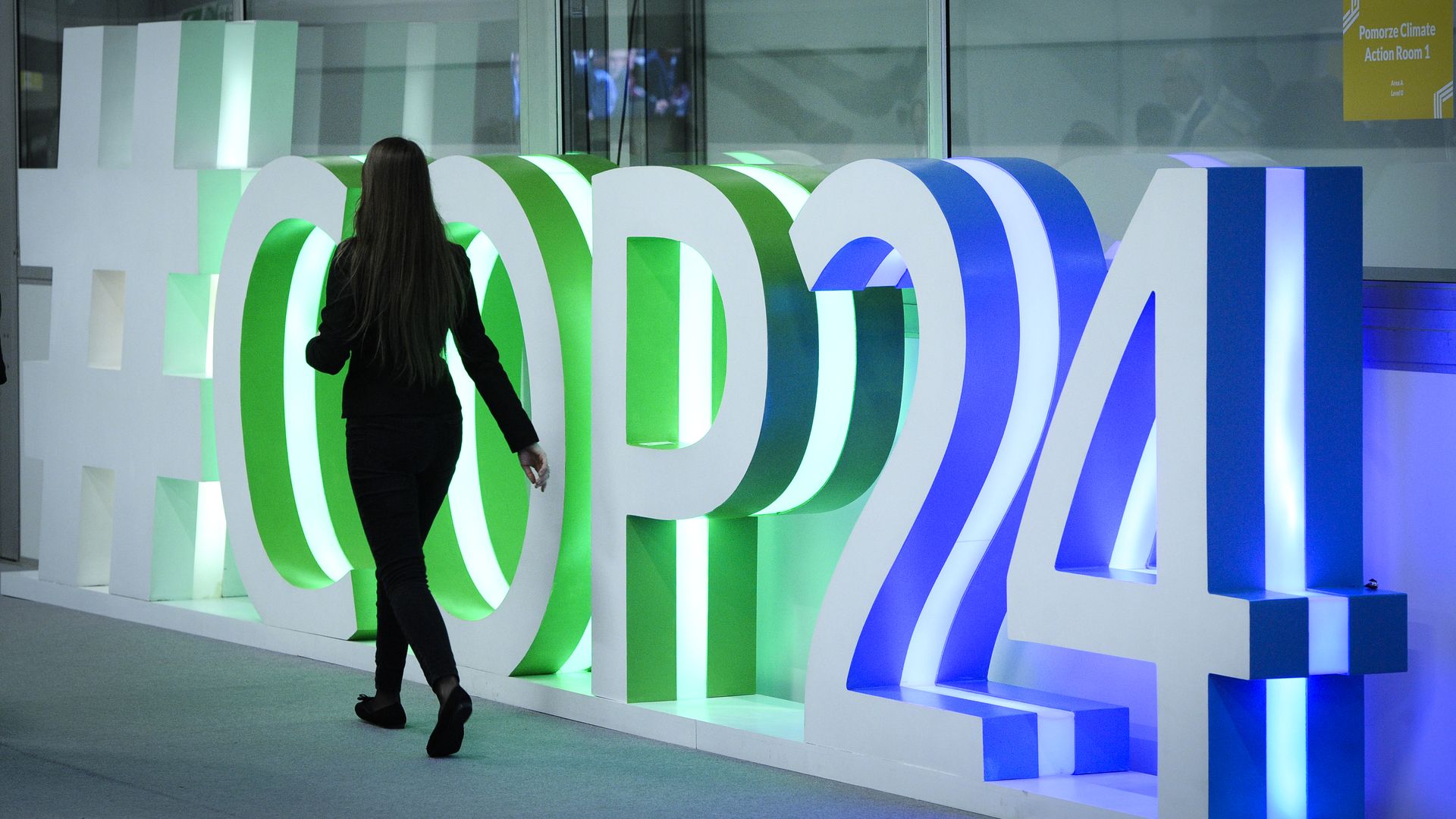 eople are seen walking pas a COP24 logo during the Katowice Climate Conference in Katowice, Poland.