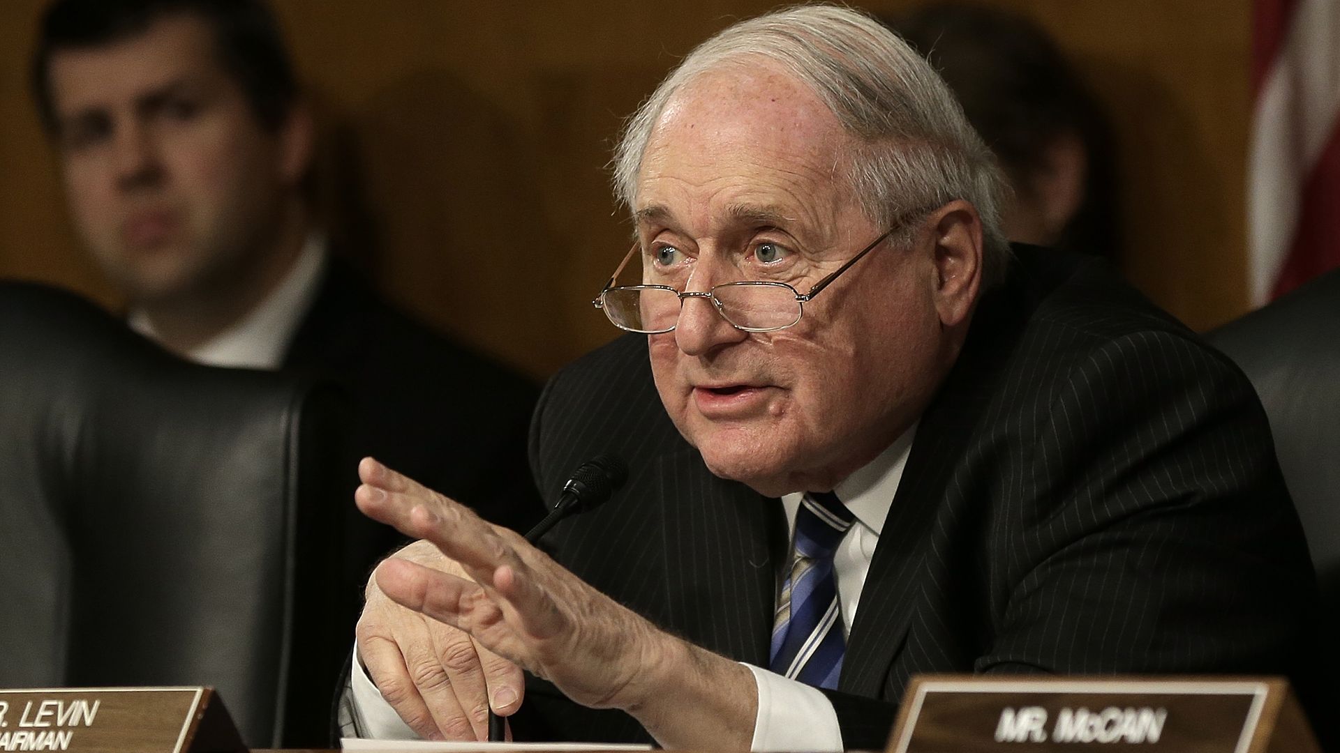Sen. Carl Levin gestures while seated at a podium