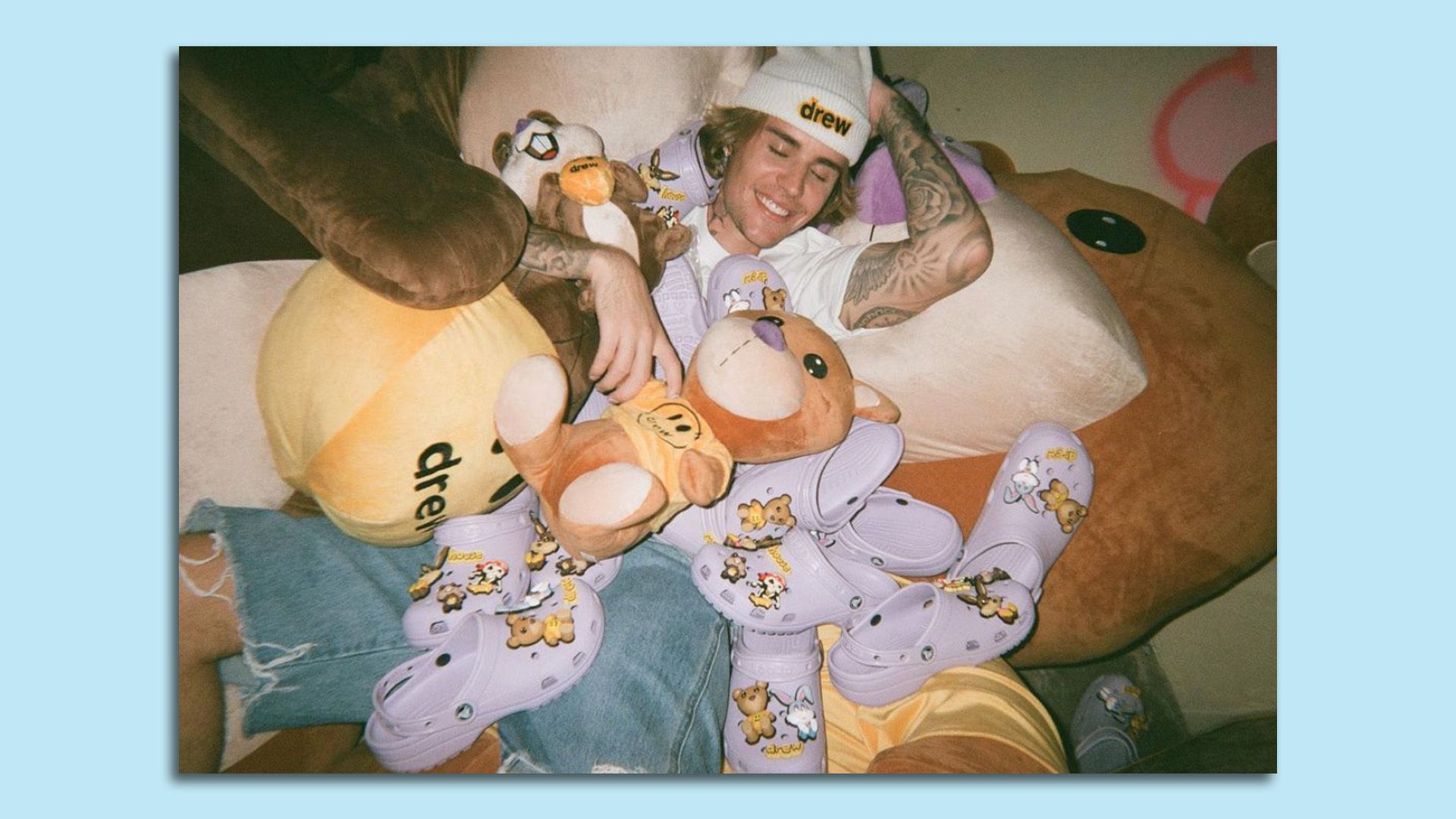Image of Justin Bieber laying with a ton of purple crocs