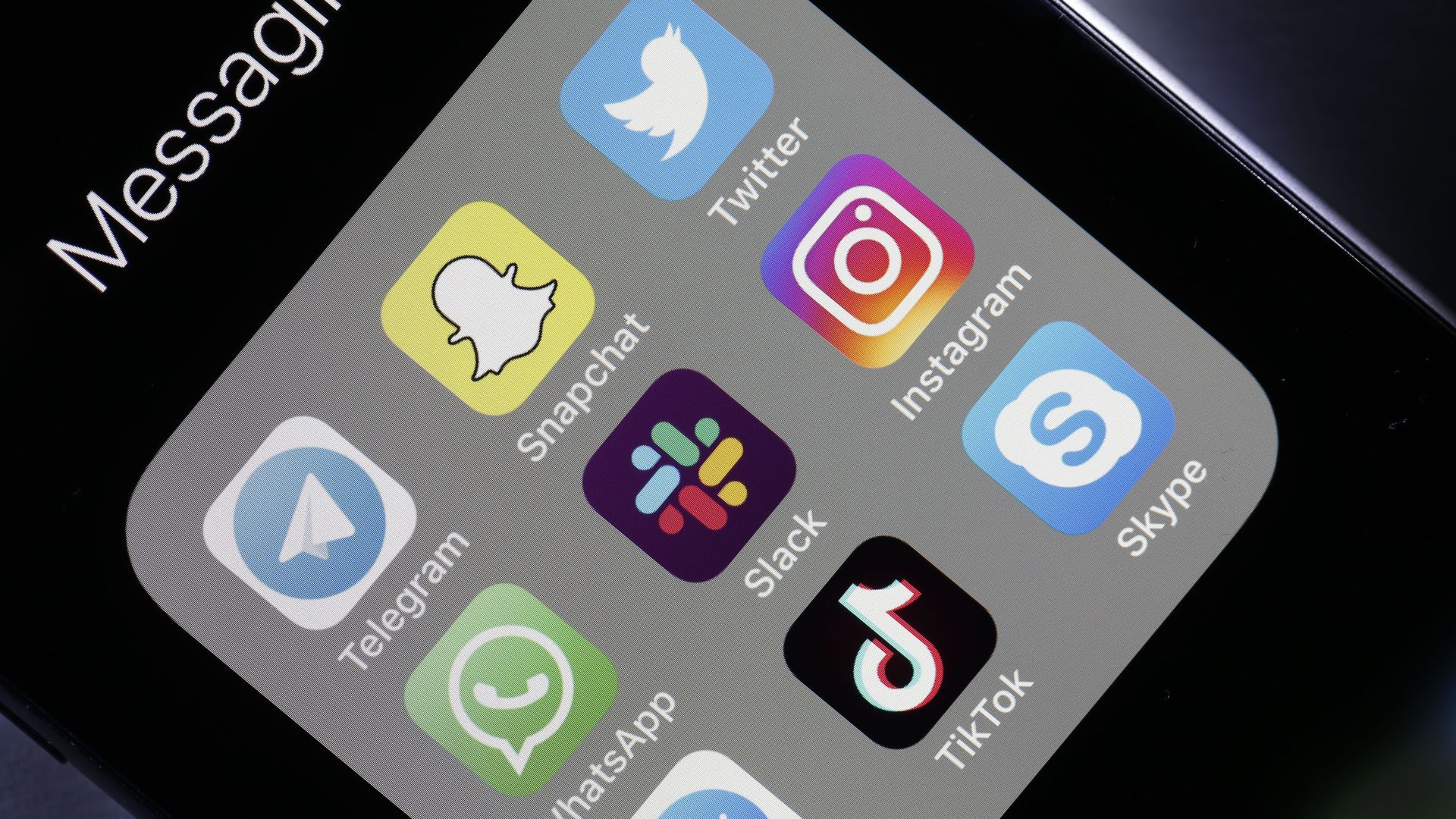 Phone with messaging apps. Slack app is in the middle