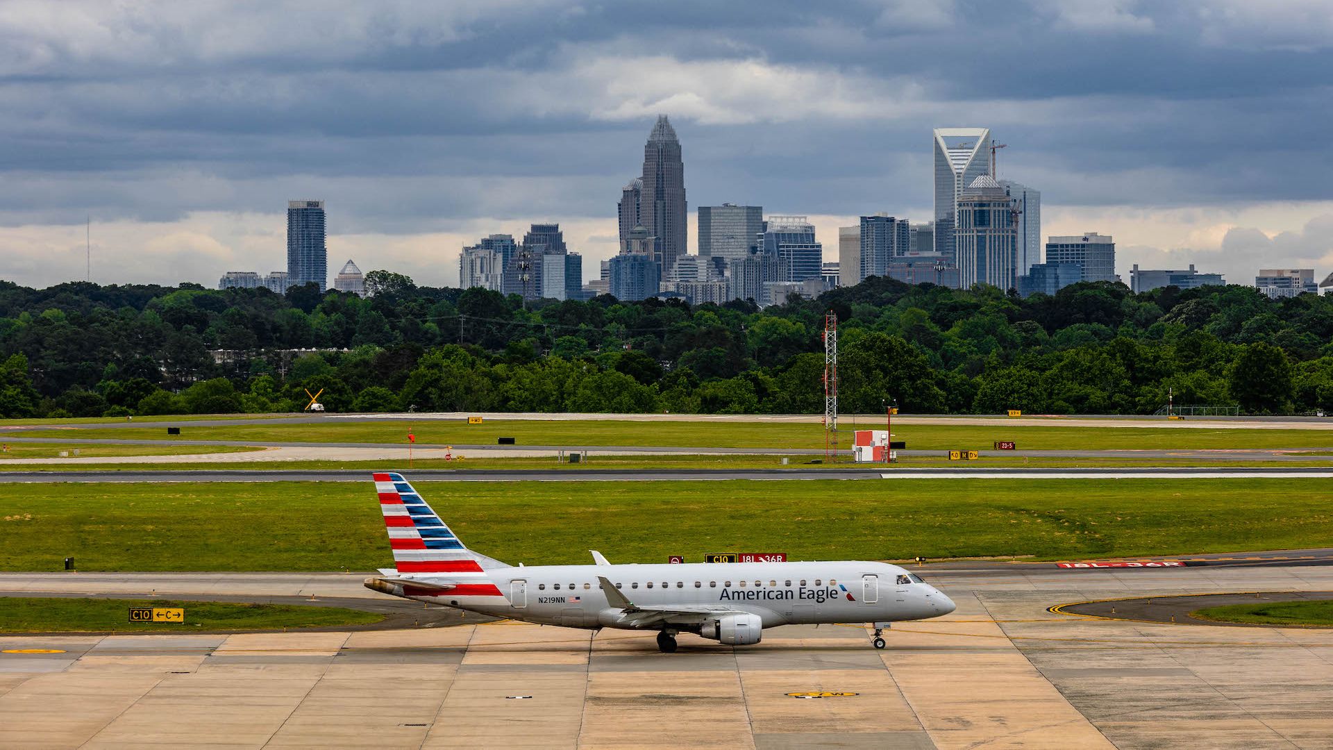 A plane on a runaway. There is a city skyline in the background. 