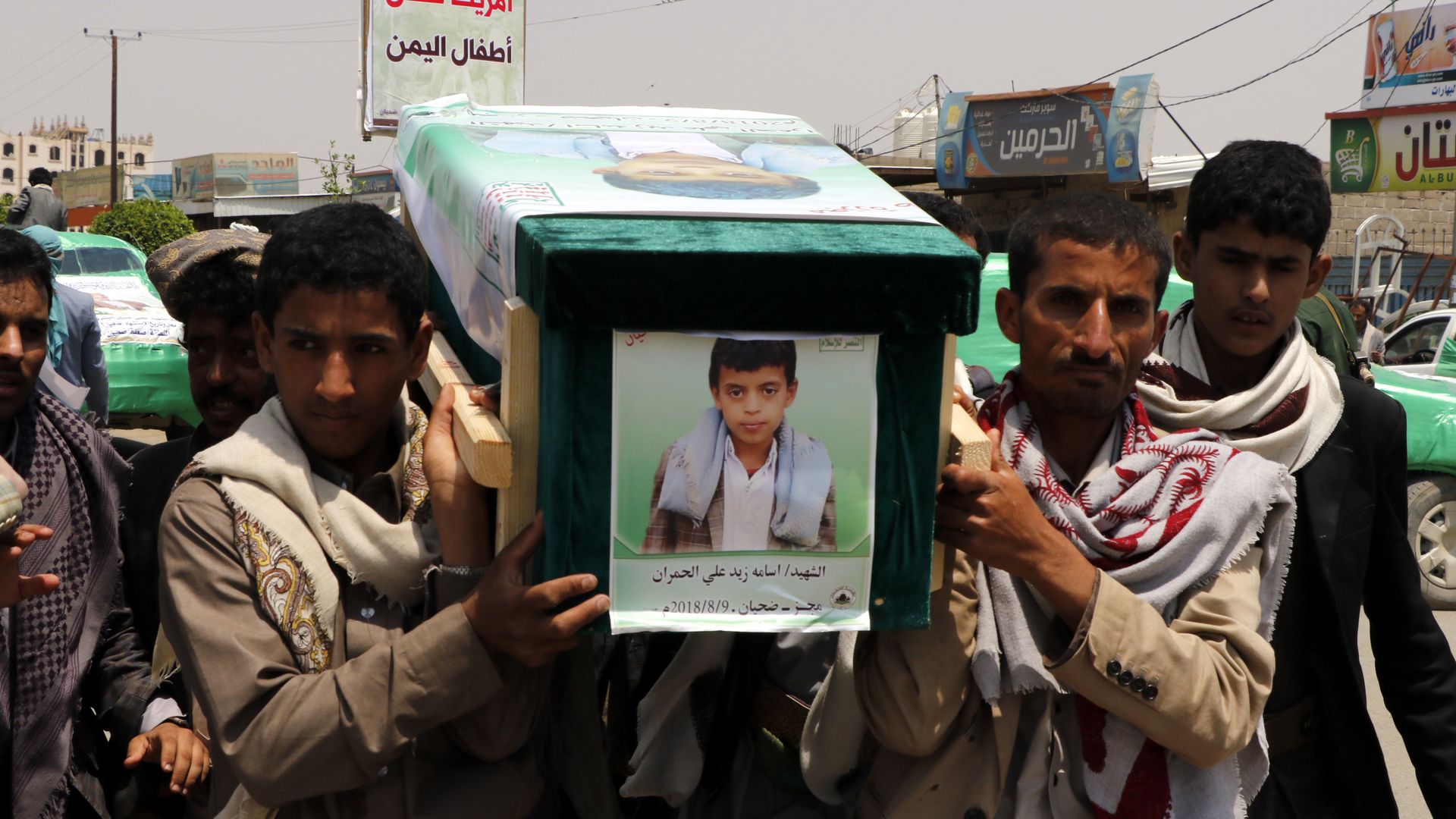 Mourners carry the coffin of a child.