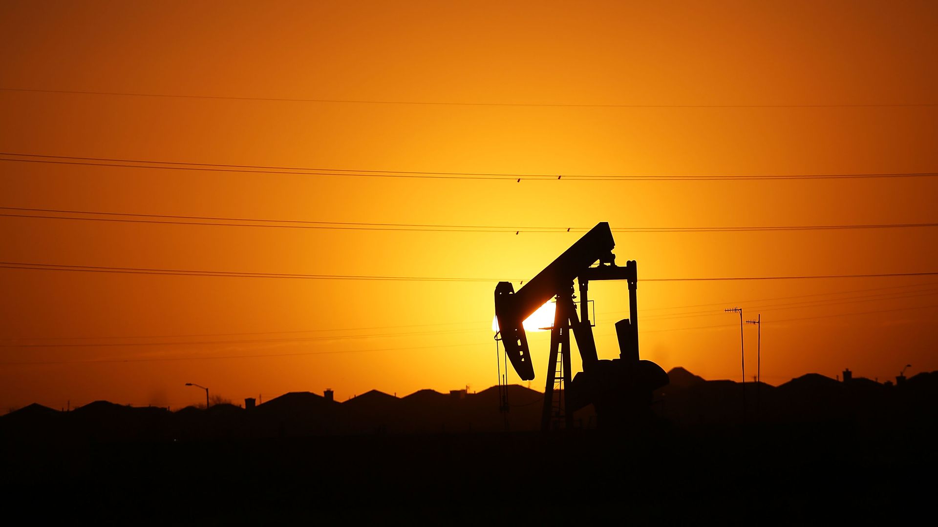 Oil rig against an orange sky.