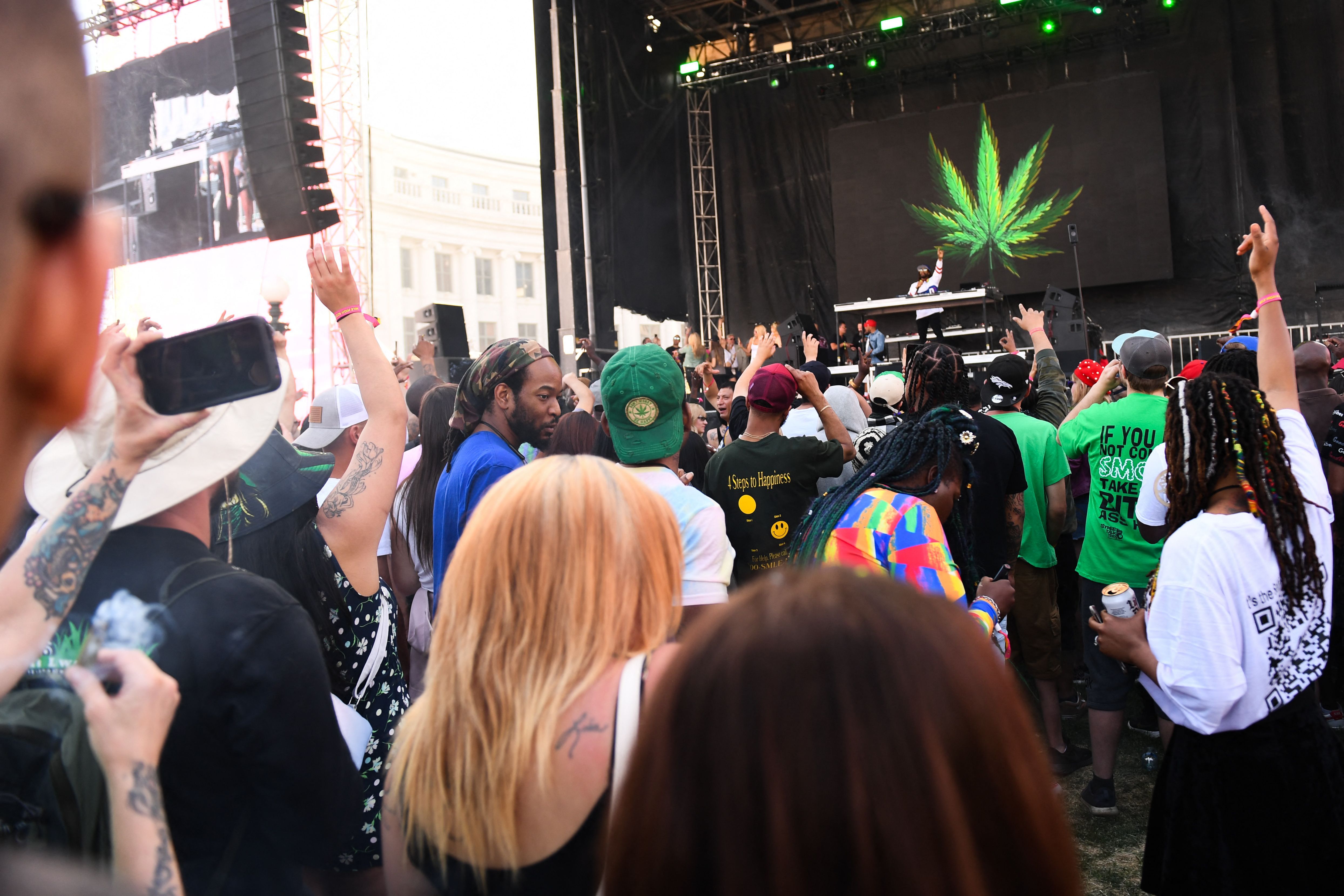 A crowd gathers in front of a large stage. 
