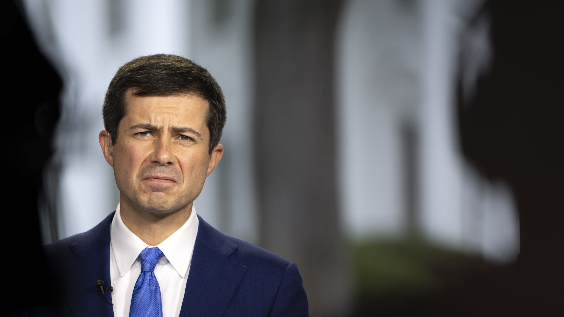Pete Buttigieg scowls during a television interview in front of the White House