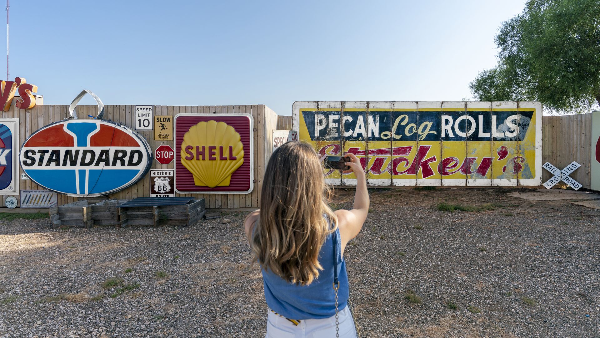 Woman taking a photo of vintage signing during a Route 66 Illinois Road Trip.