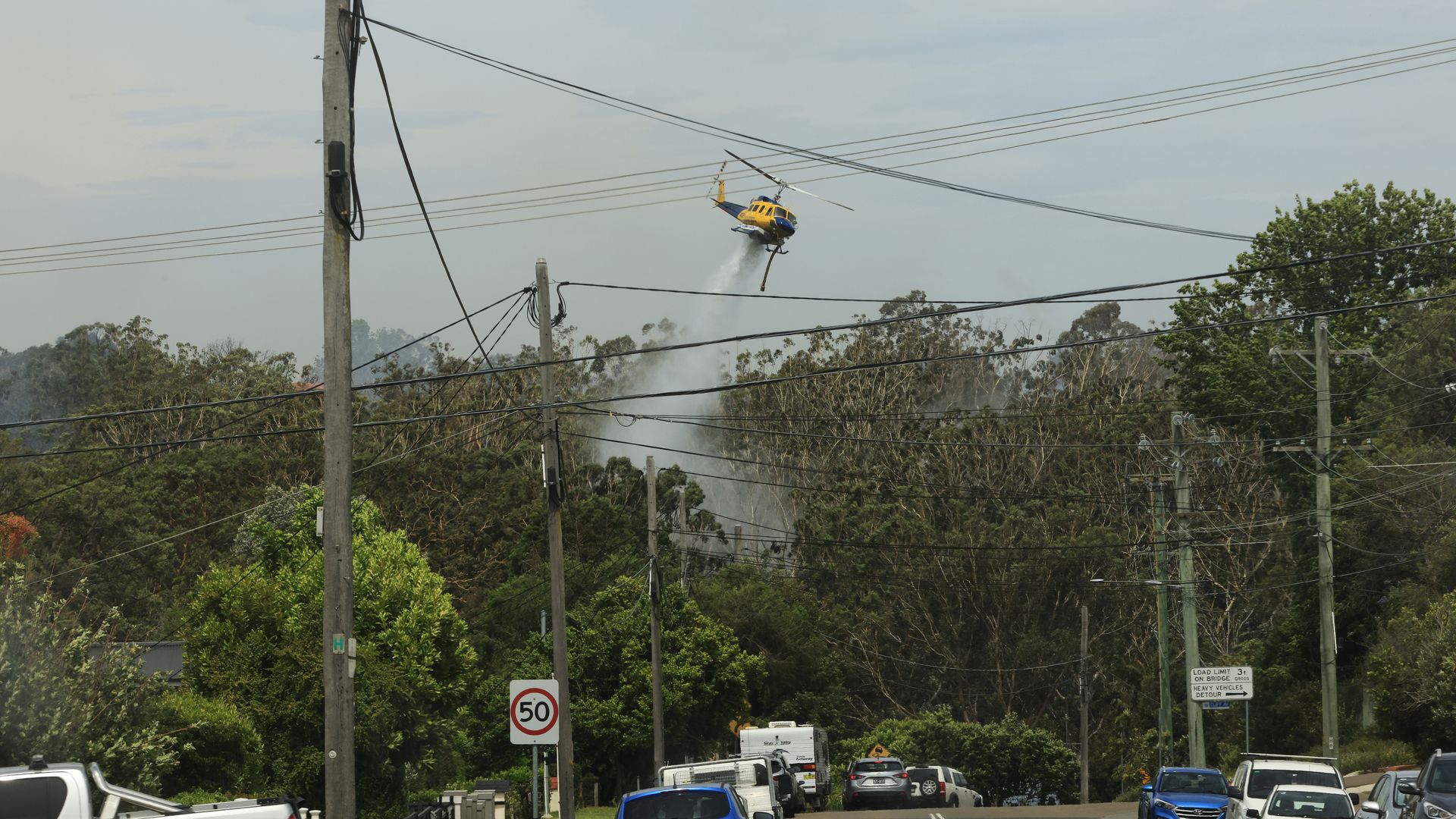 Helicopters are seen water bombing an out of control bushfire at Northmead on November 29, 2020 in Sydney, Australia.