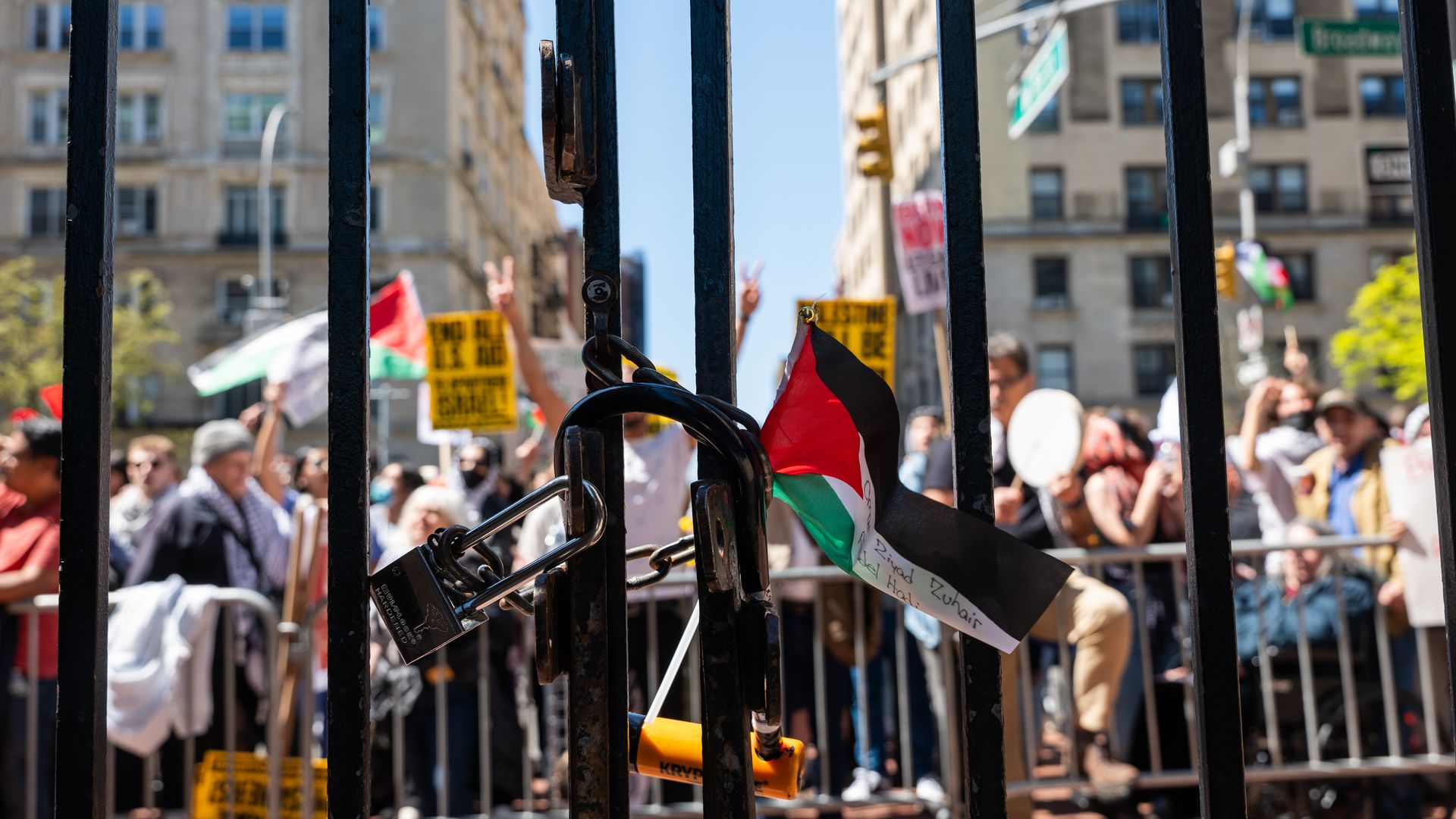 Pro-Palestinian protestors are seen through iron gates