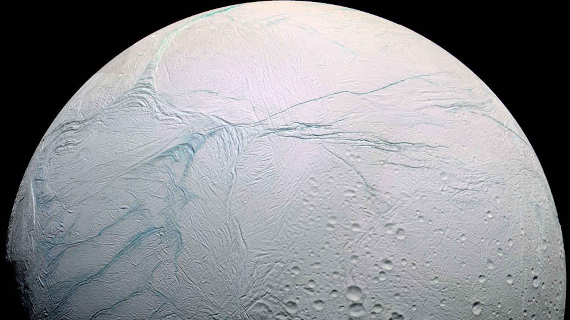 A view of Saturn's moon Enceladus, showing off its distressed, striped surface