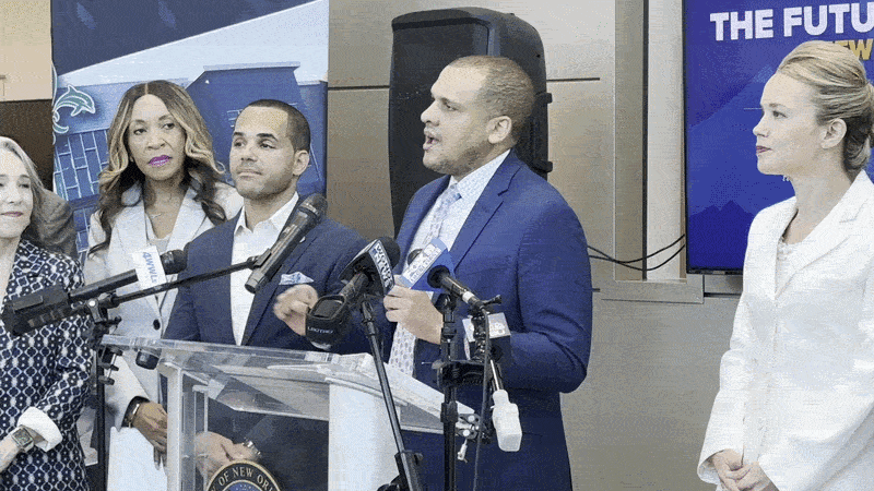 Image shows Councilmember Jason Hughes talking at a podium.