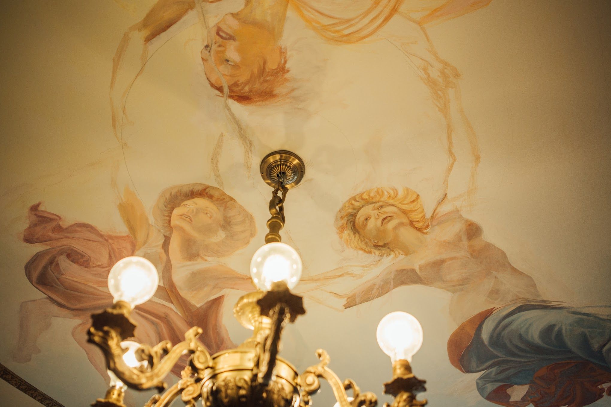 A photo of murals of angels on a ceiling.