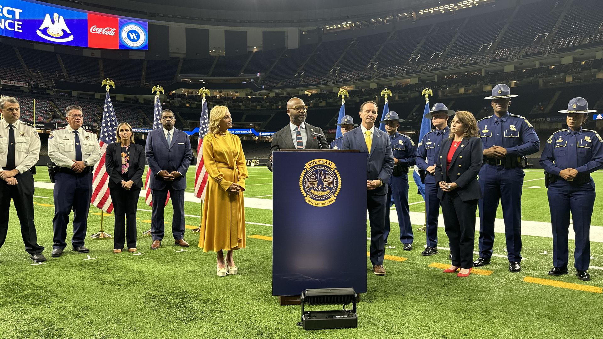 New Orleans District Attorney Jason Williams speaks at a podium during a press conference. Behind him stands law enforcement officers and Gov.-elect Jeff Landry, Attorney General-elect Liz Murrill and Landry's wife, Sharon Landry.