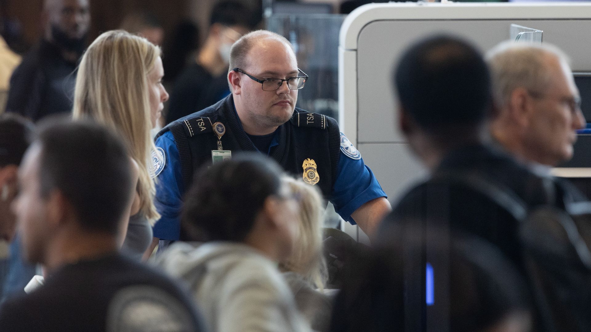 A TSA agent at Bush Airport in Houston surrounded by travelers