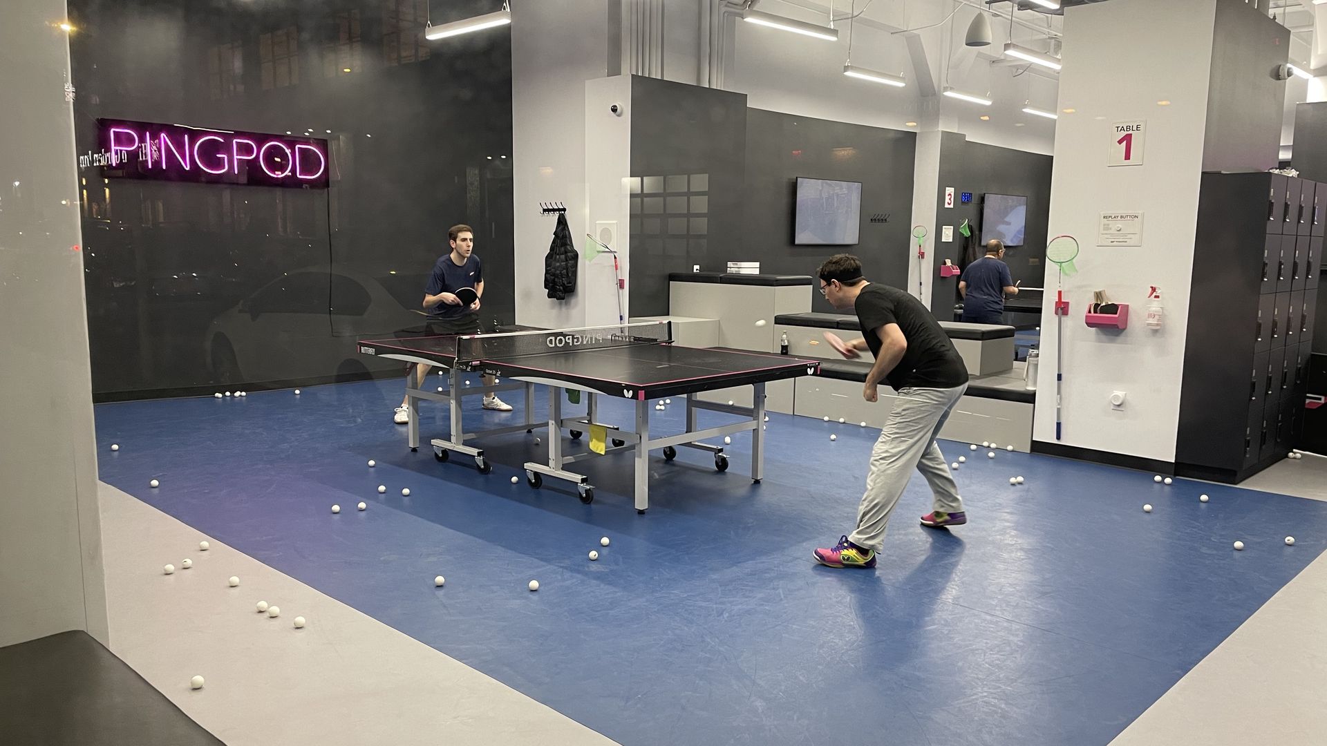 Two men playing ping-pond at an indoor studio called Pingpod.