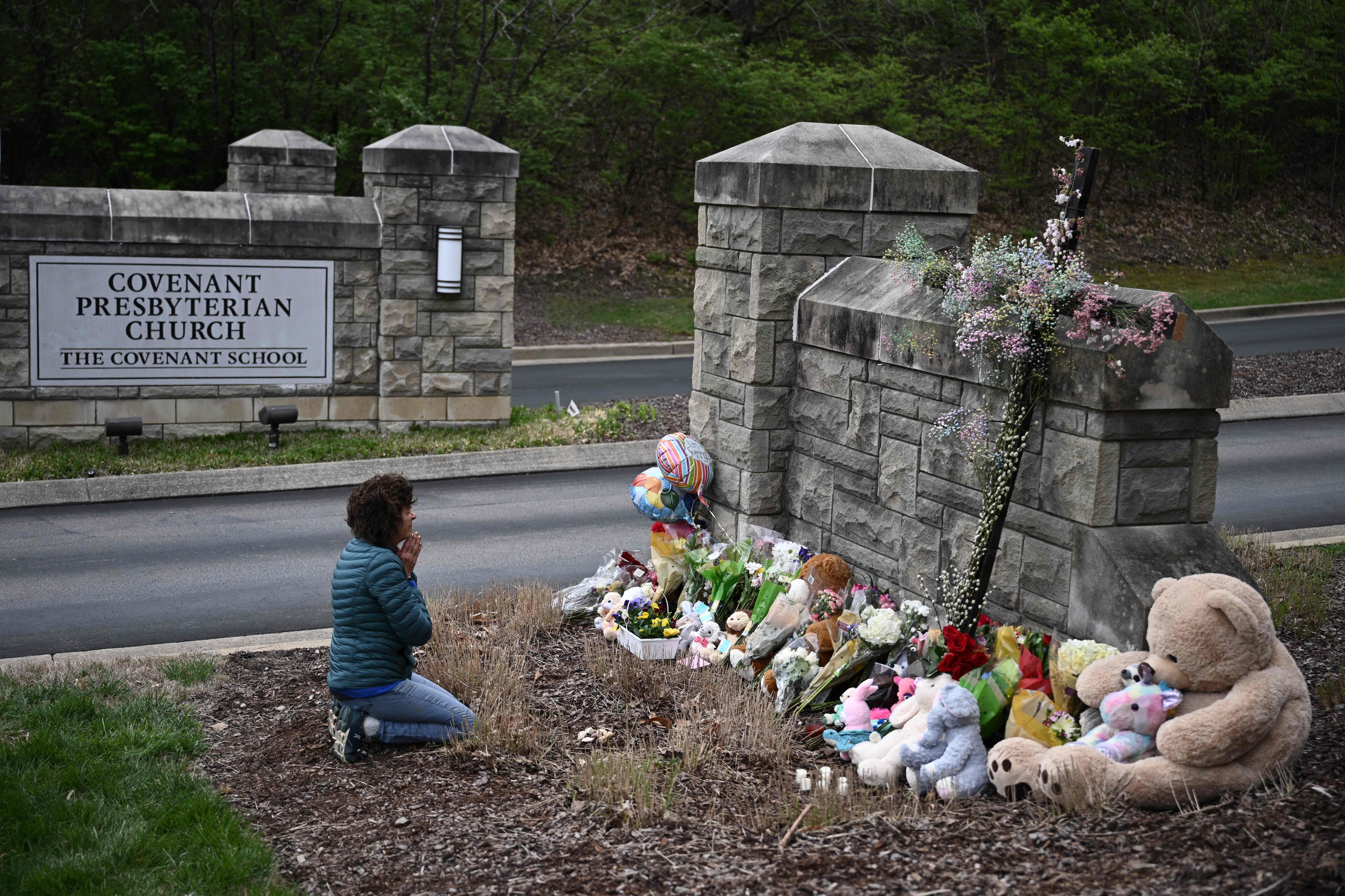 Woman praying at makeshift memorial
