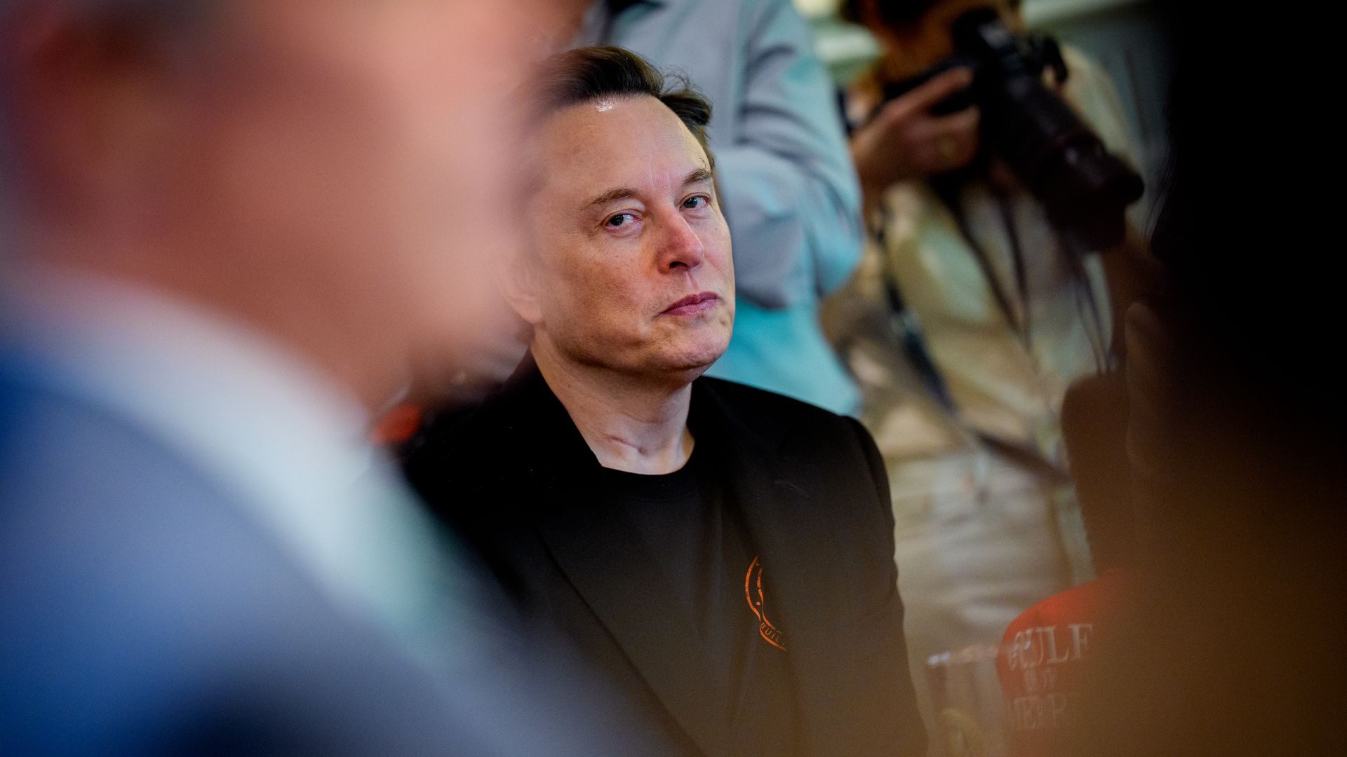 Elon Musk is showed with an unfocused image of another person in the foreground.