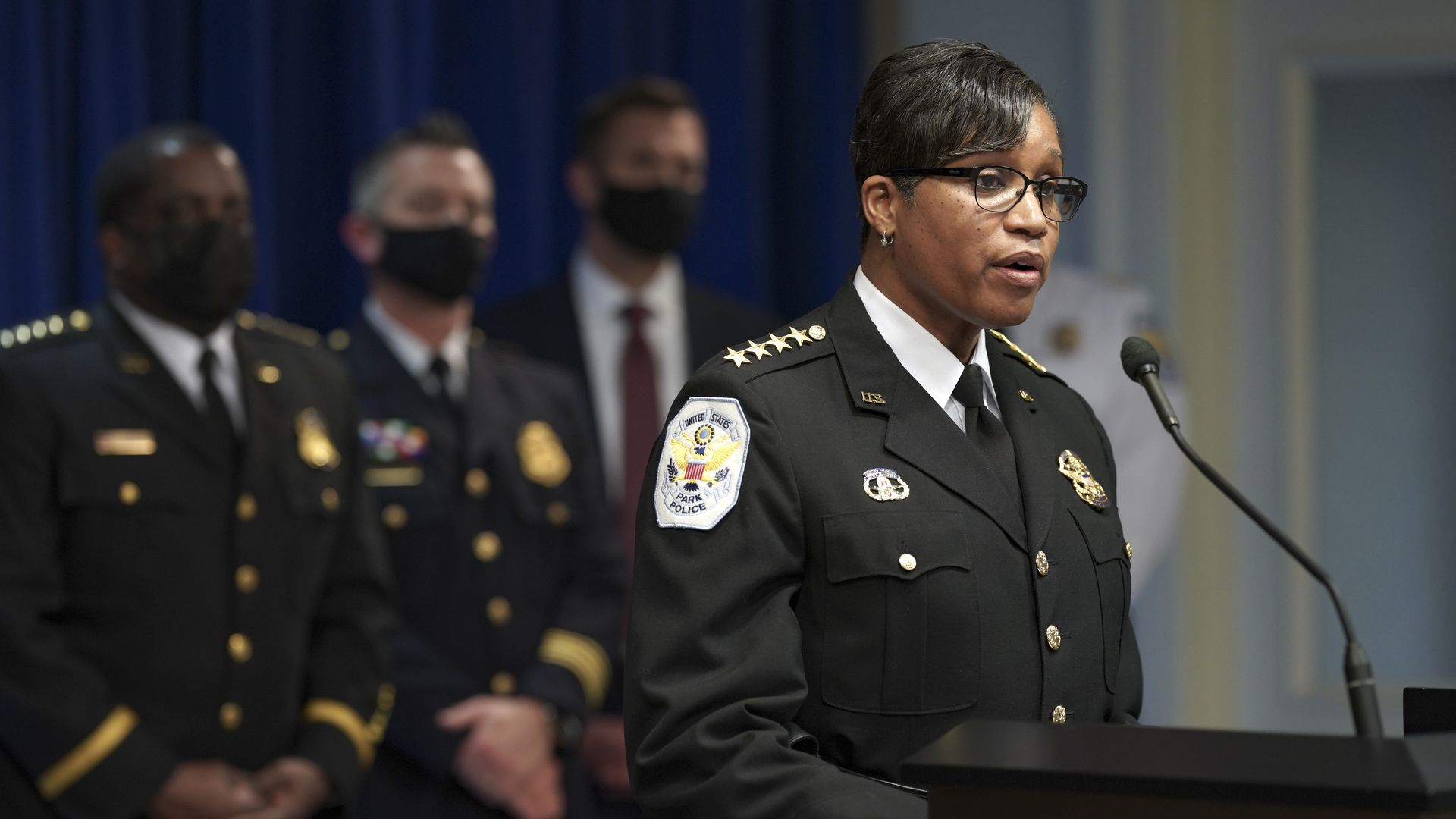 Pamela Smith speaks at a podium in her U.S. Park Police uniform.