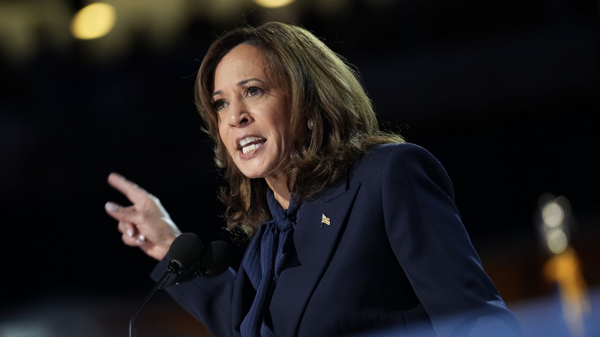 Kamala Harris speaks and points to her right.